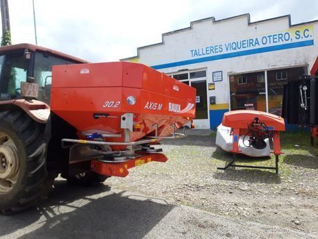 Un tractor está estacionado frente a un edificio que dice talleres viqueira otero