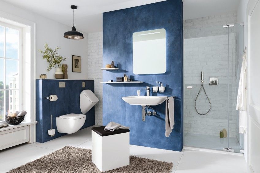 Ein Badezimmer mit Toilette, Waschbecken, Spiegel und ebenerdiger Dusche