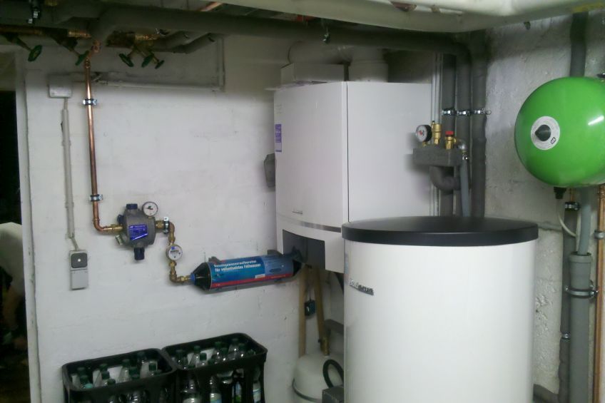 Ein Raum mit einer weißen Heizung und einem grünen Tank