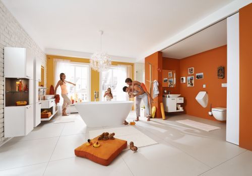 Eine Familie spielt in einem Badezimmer mit orangefarbenen Wänden.
