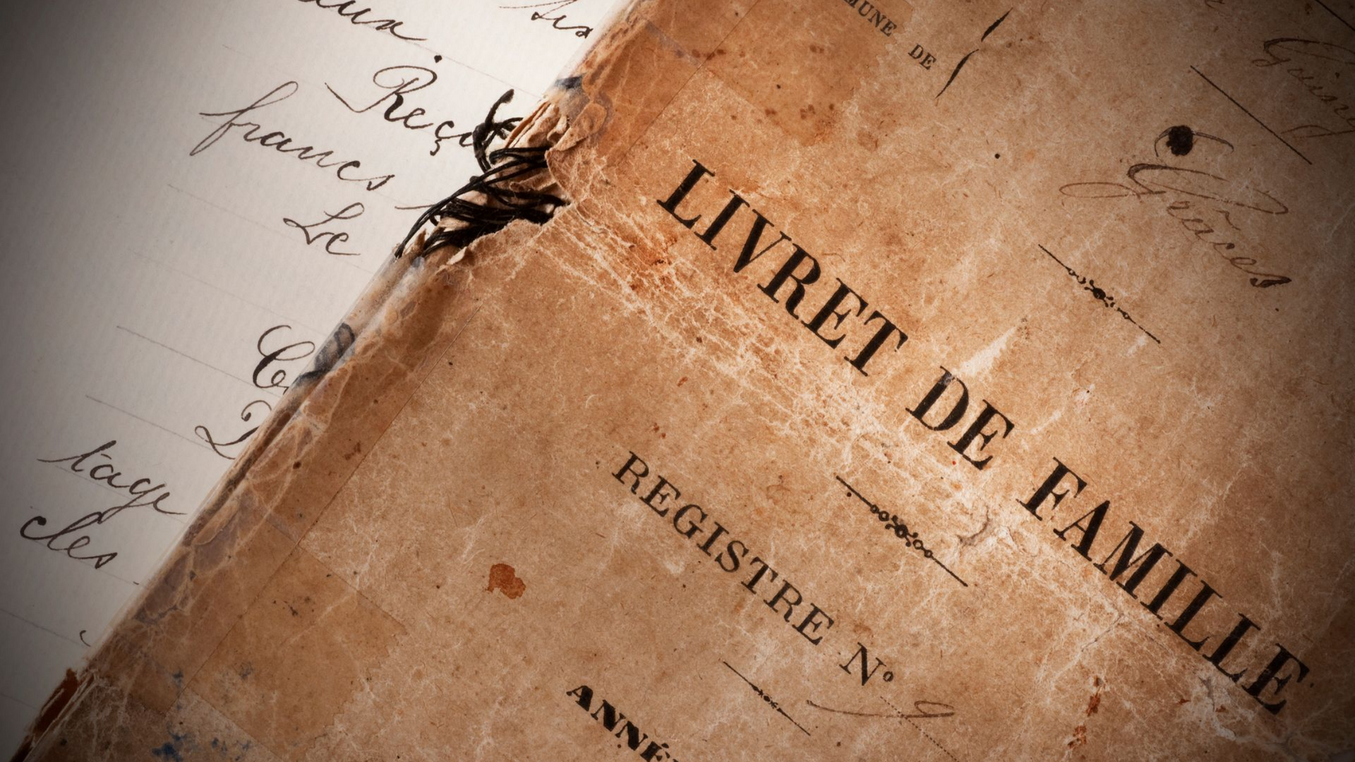 Gros plan sur un livret de famille ancien et abîmé, rédigé en français.