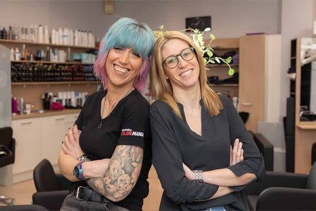 Zwei Frauen posieren in einem Friseursalon für ein Foto.