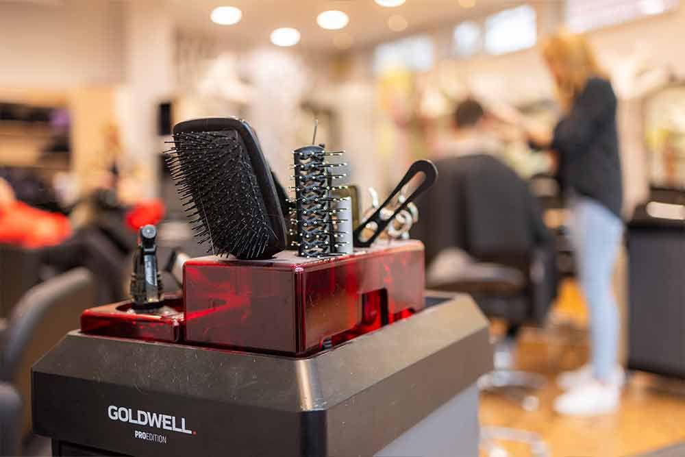 Eine Frau lässt sich in einem Friseursalon die Haare schneiden.