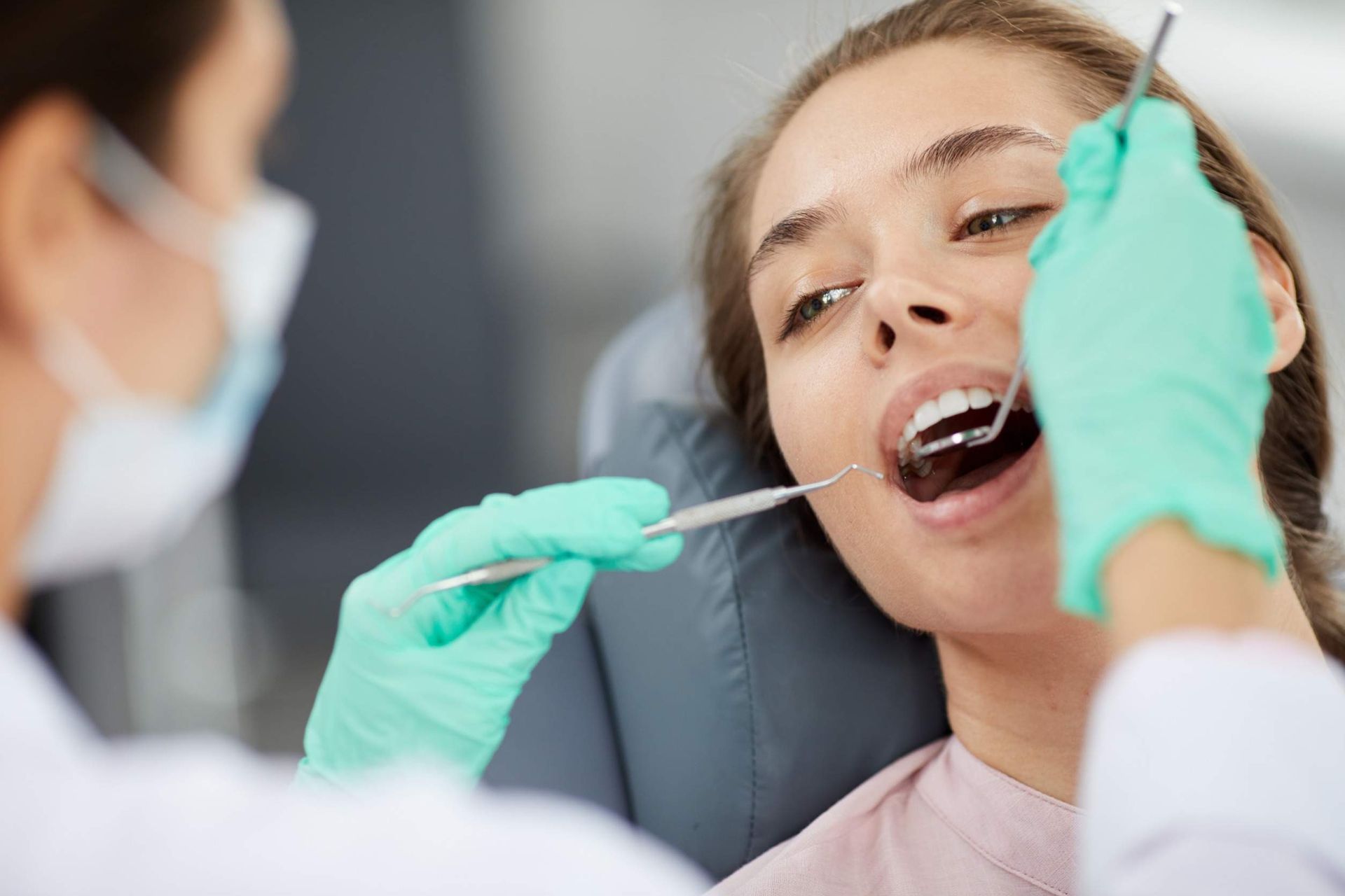 Una mujer está siendo examinada por un dentista.
