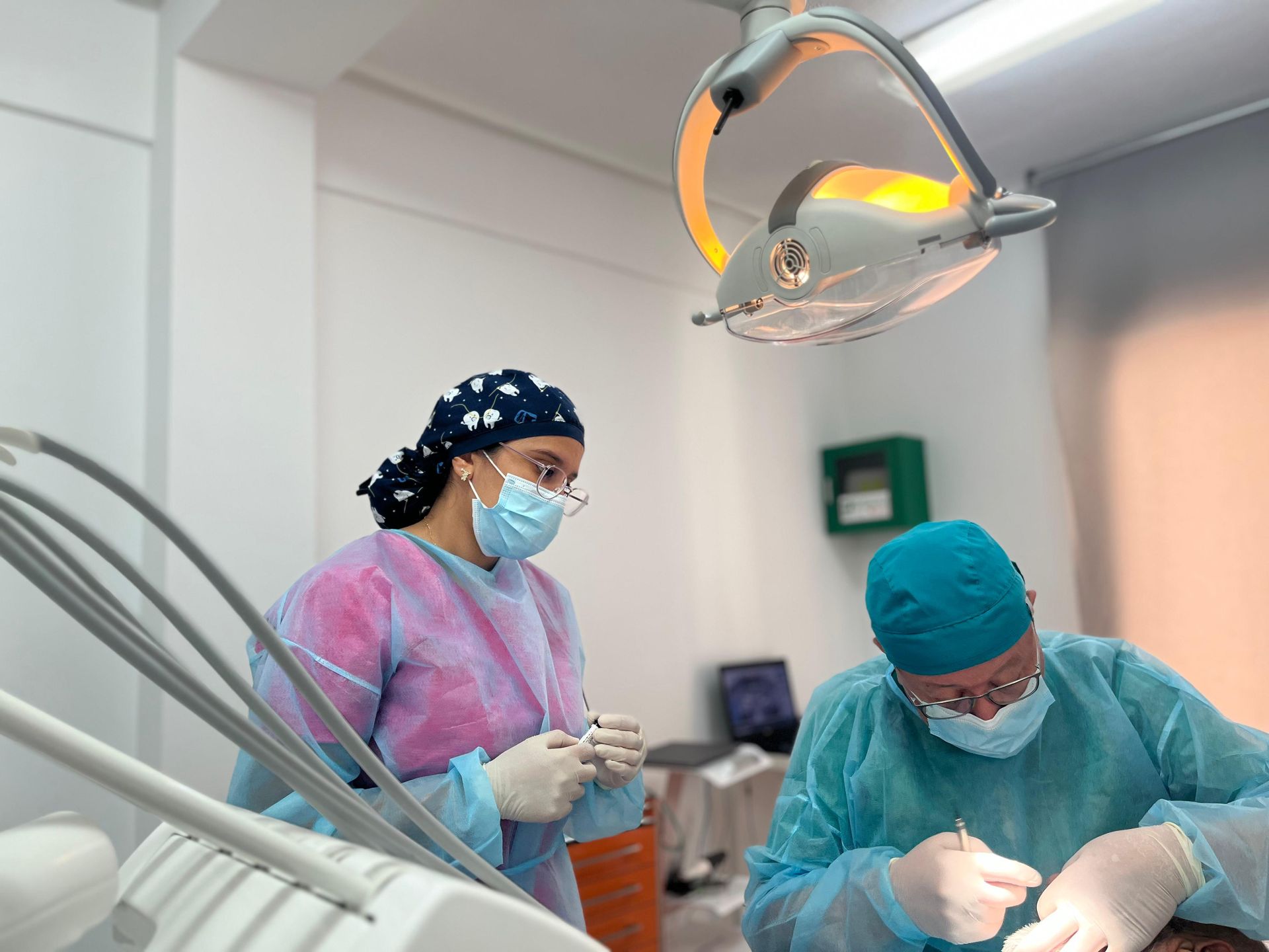 Un dentista está trabajando con un paciente en un consultorio dental.