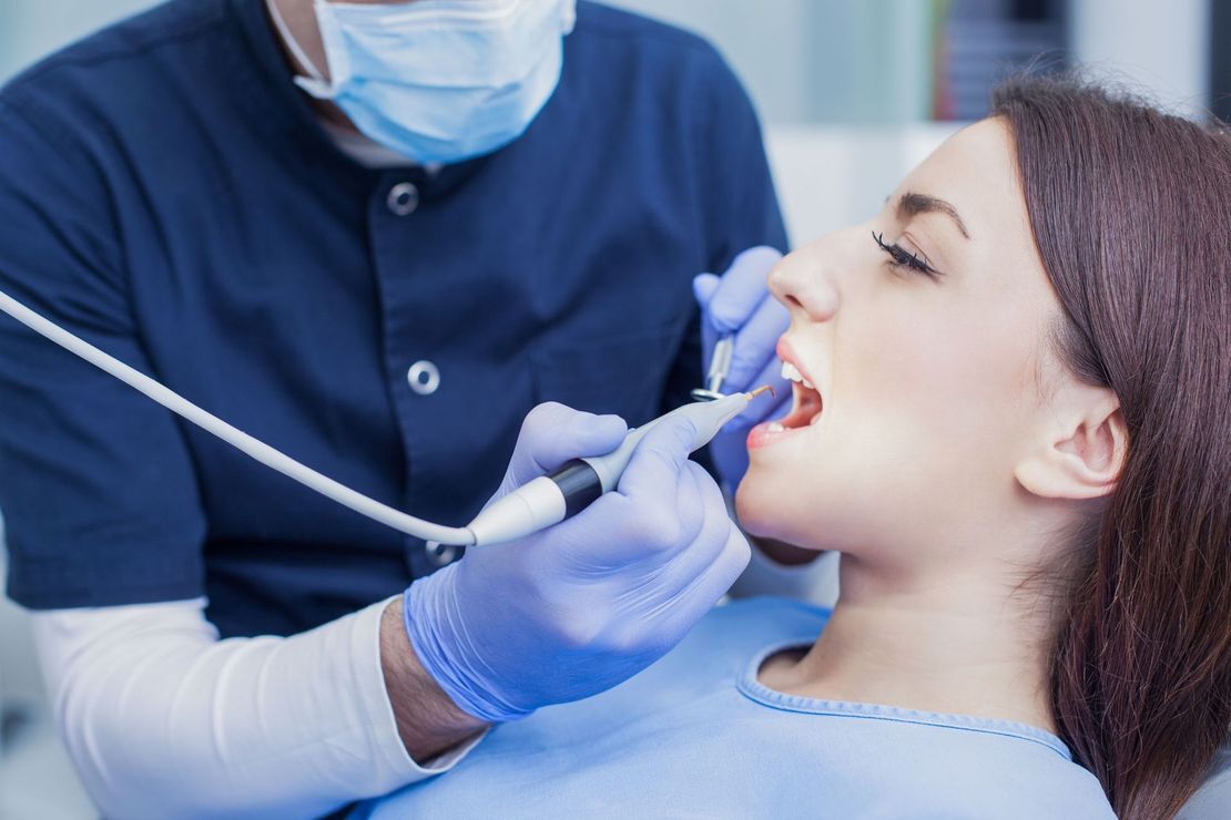 Una mujer está siendo examinada por un dentista.