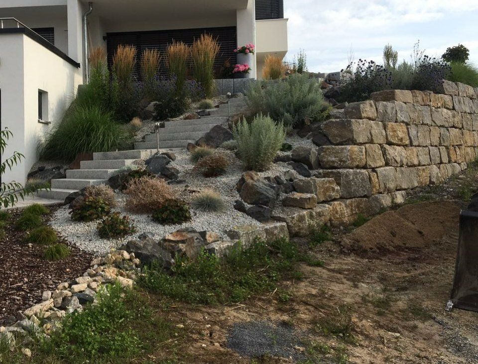Garten mit Steinmauer und Blumenbeet