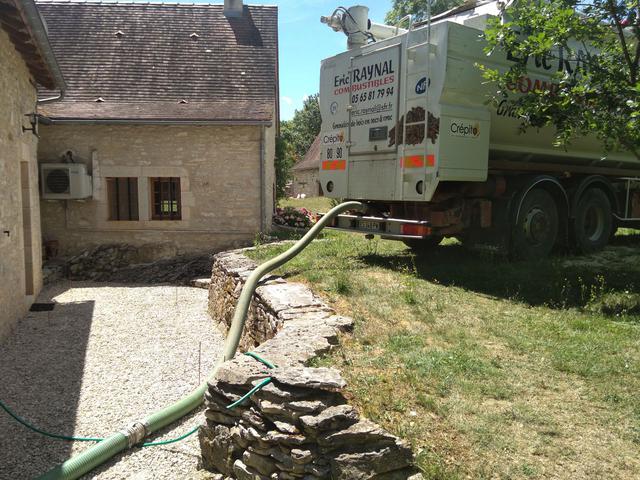 Vue sur l'arrière du poids lourd de la société et de la façade d'une maison en pierre
