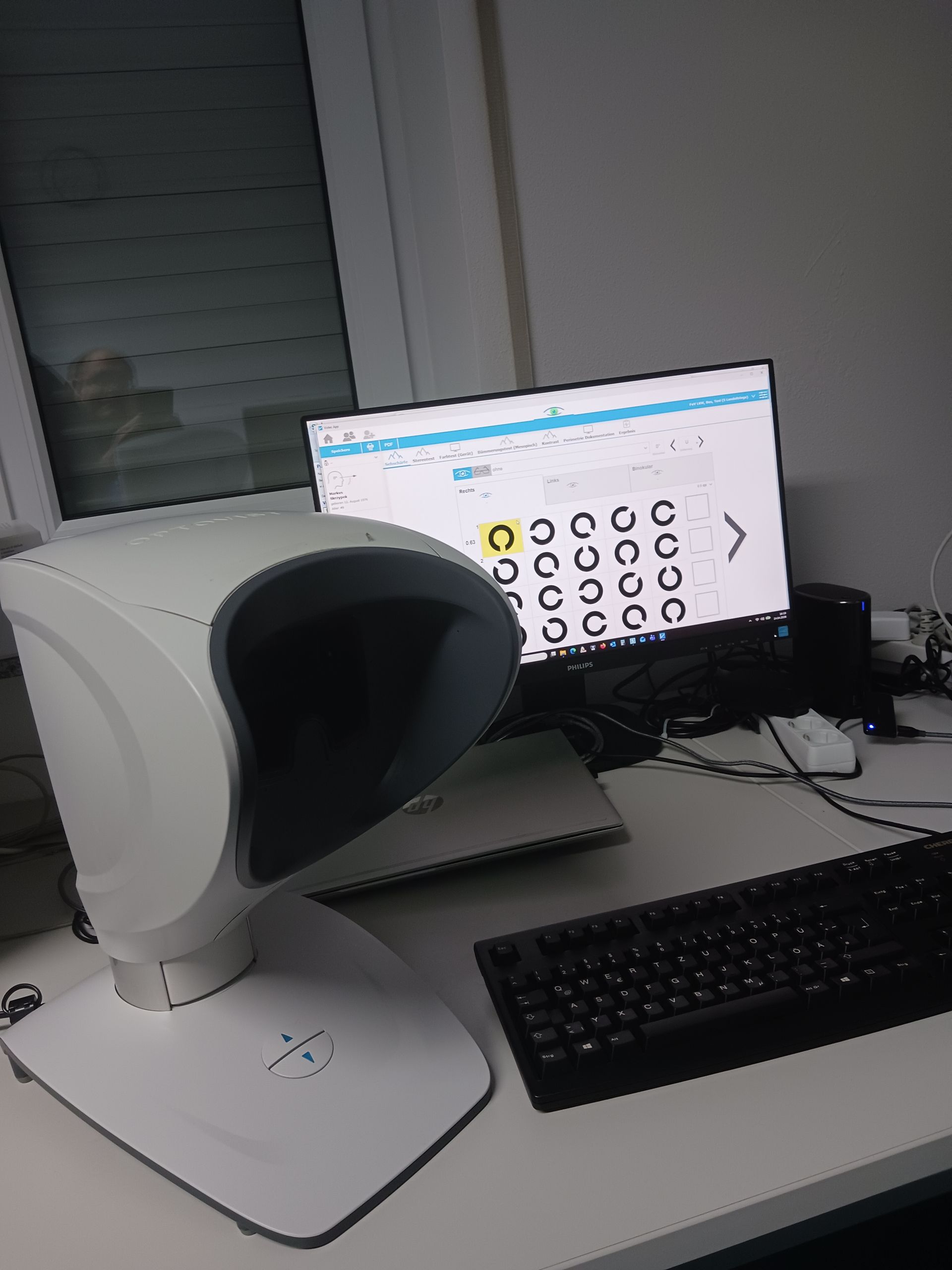 Ein Patient benutzt bei einer Augenuntersuchung eine Spaltlampe mit hellem Licht und ärztlicher Ausrüstung.
