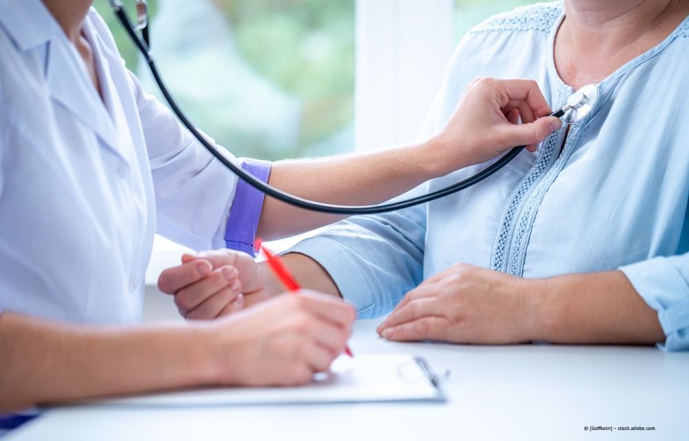 Ein Arzt überprüft in einer Klinik den Blutdruck eines Patienten mit einem Stethoskop.