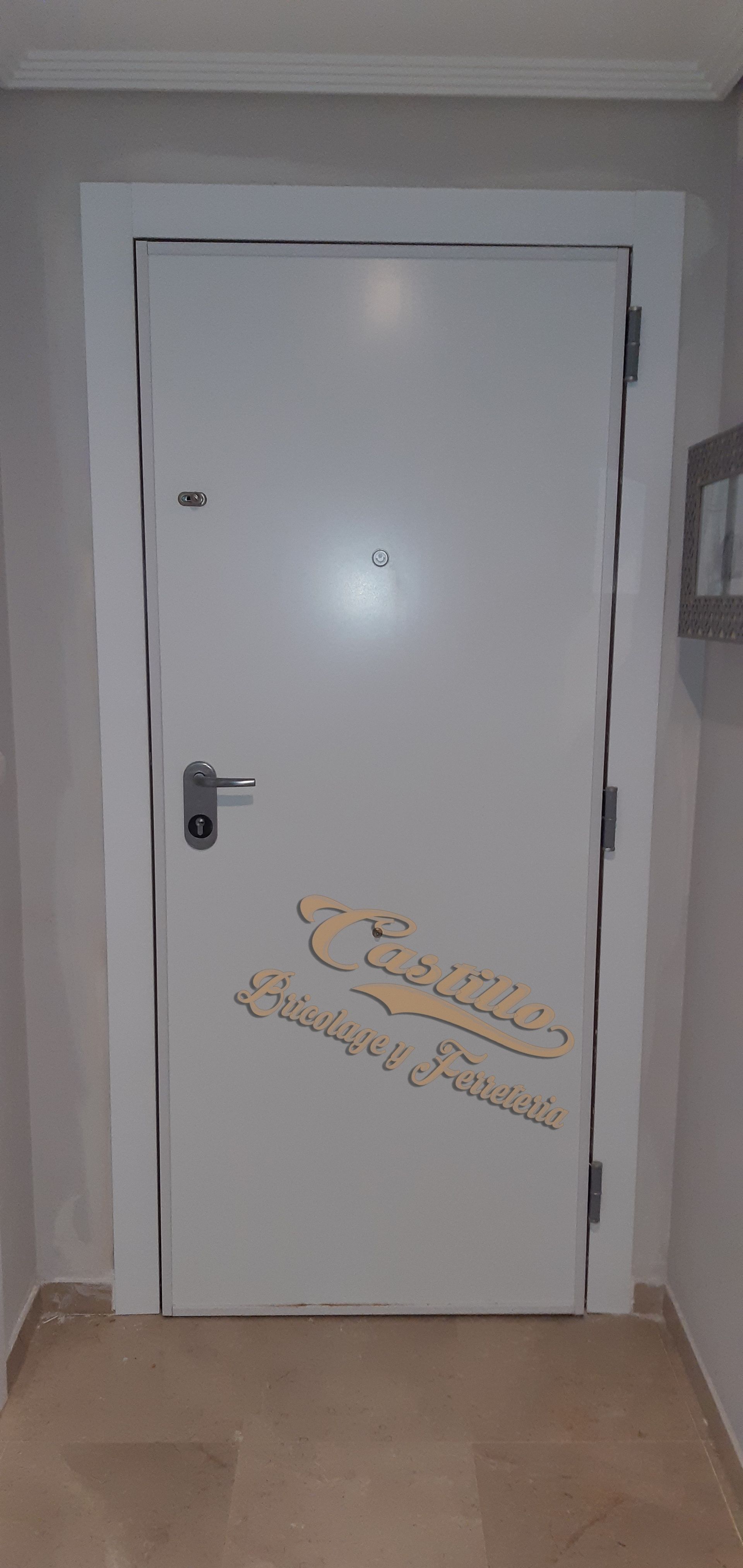 Una puerta blanca está en un pasillo al lado de una pared.