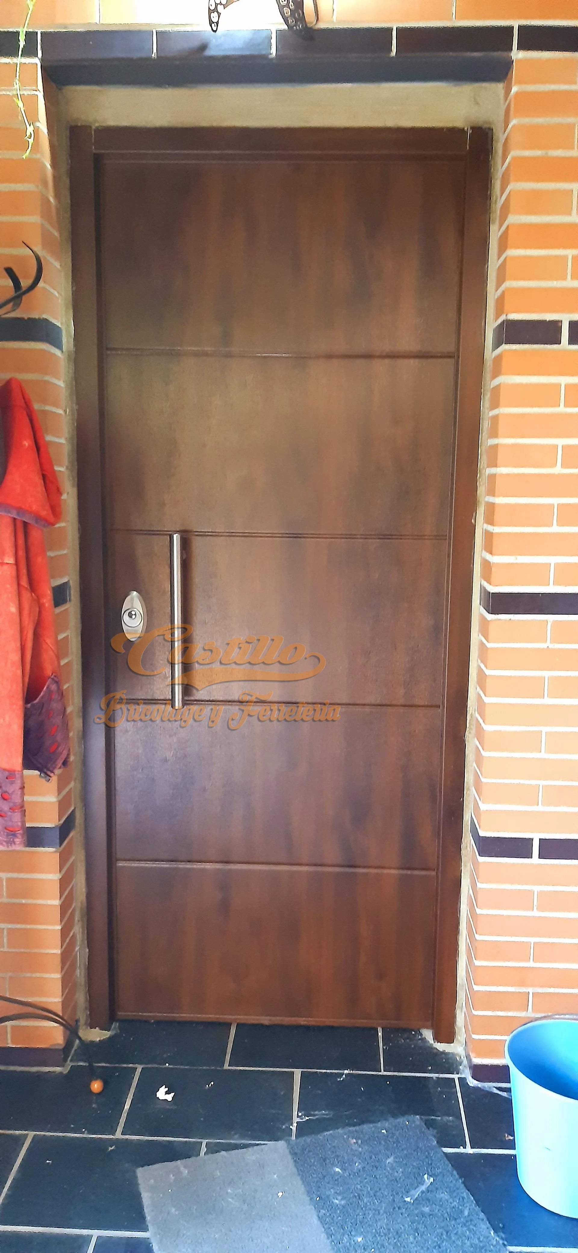 Una puerta de madera está delante de una pared de ladrillos.