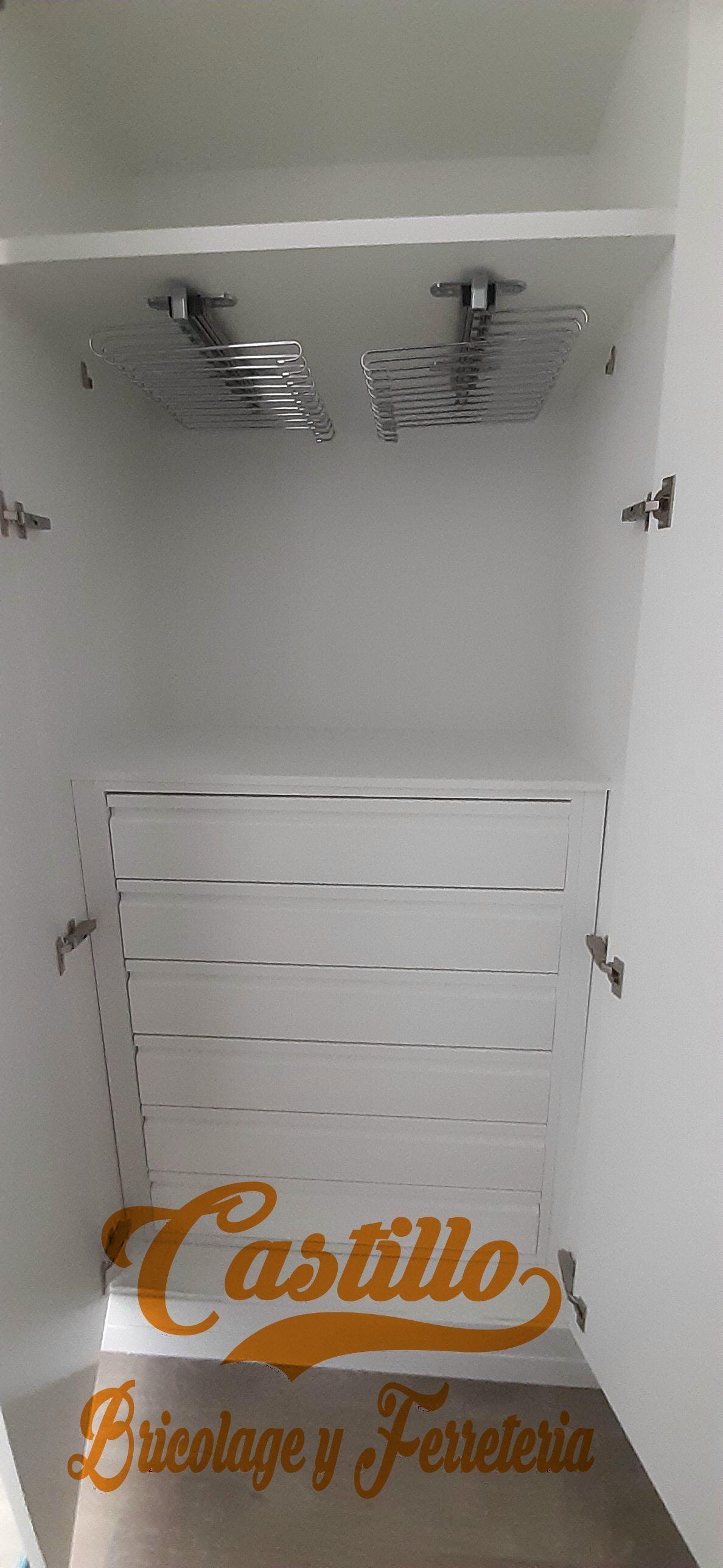 Un armario blanco con un estante y un perchero.