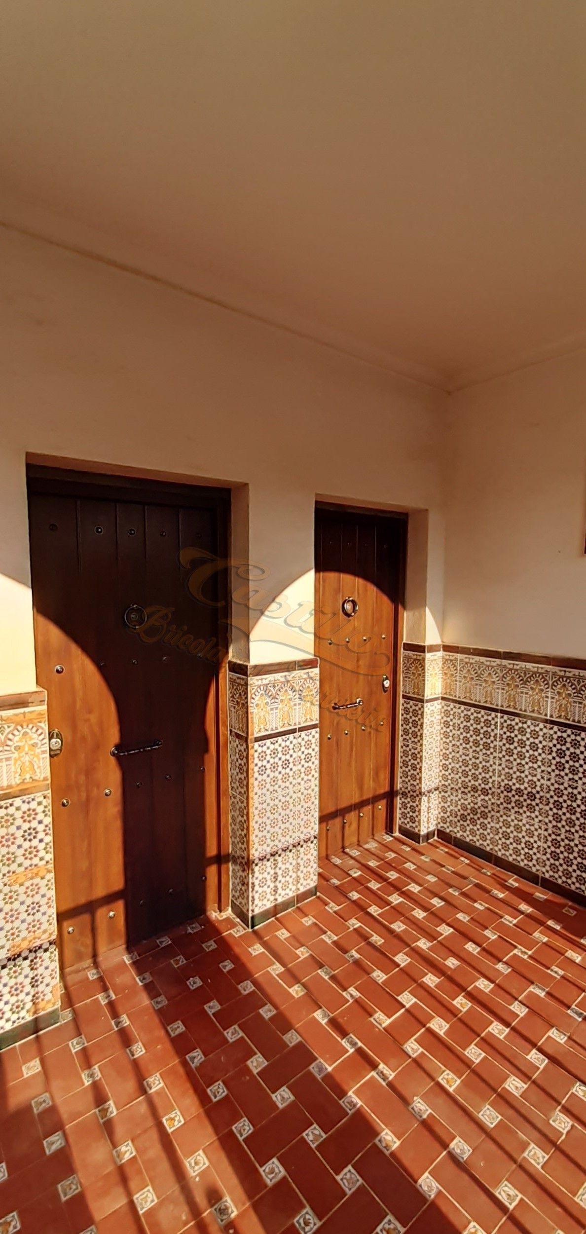 Un pasillo con dos puertas y suelo de baldosas.