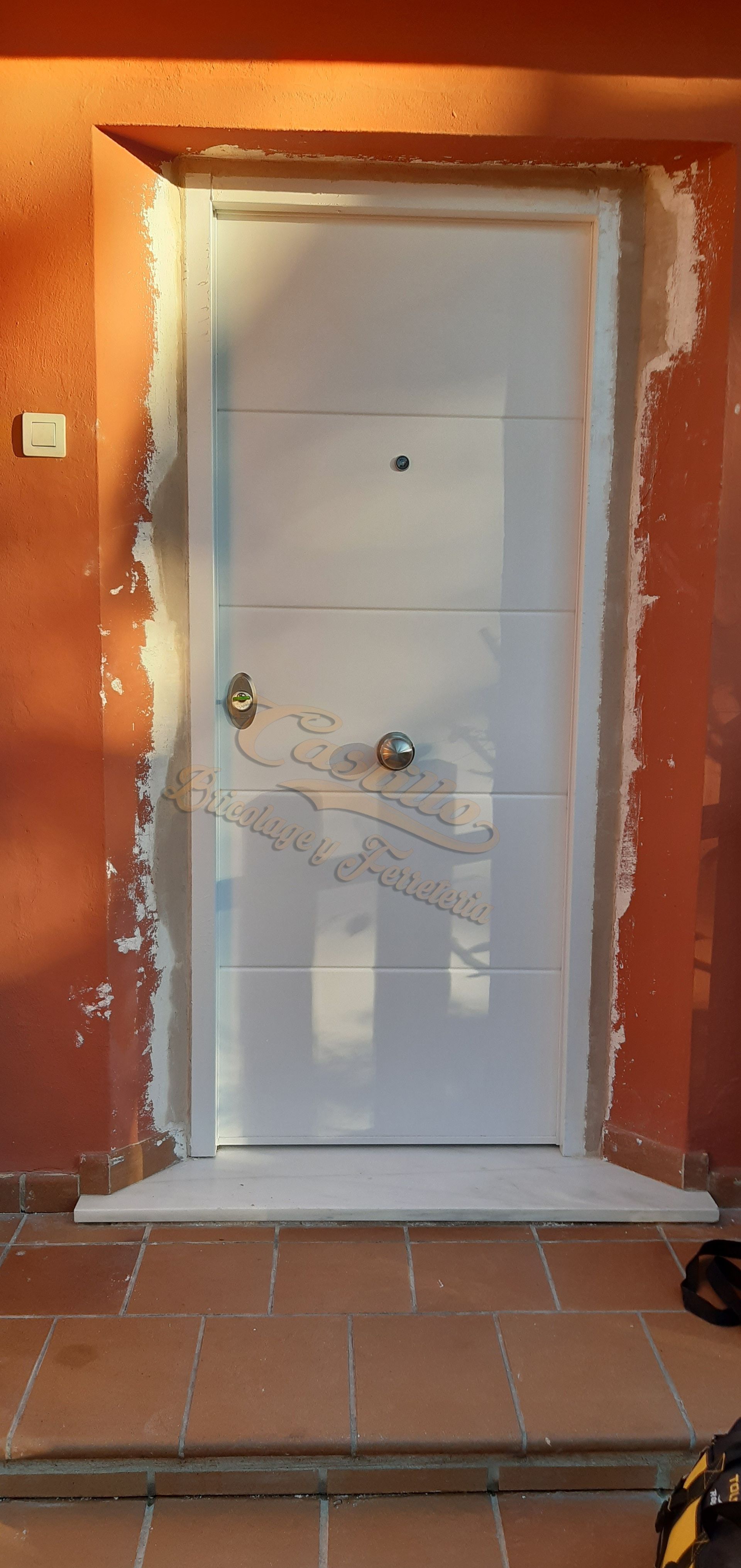 Una puerta blanca está delante de una pared roja.