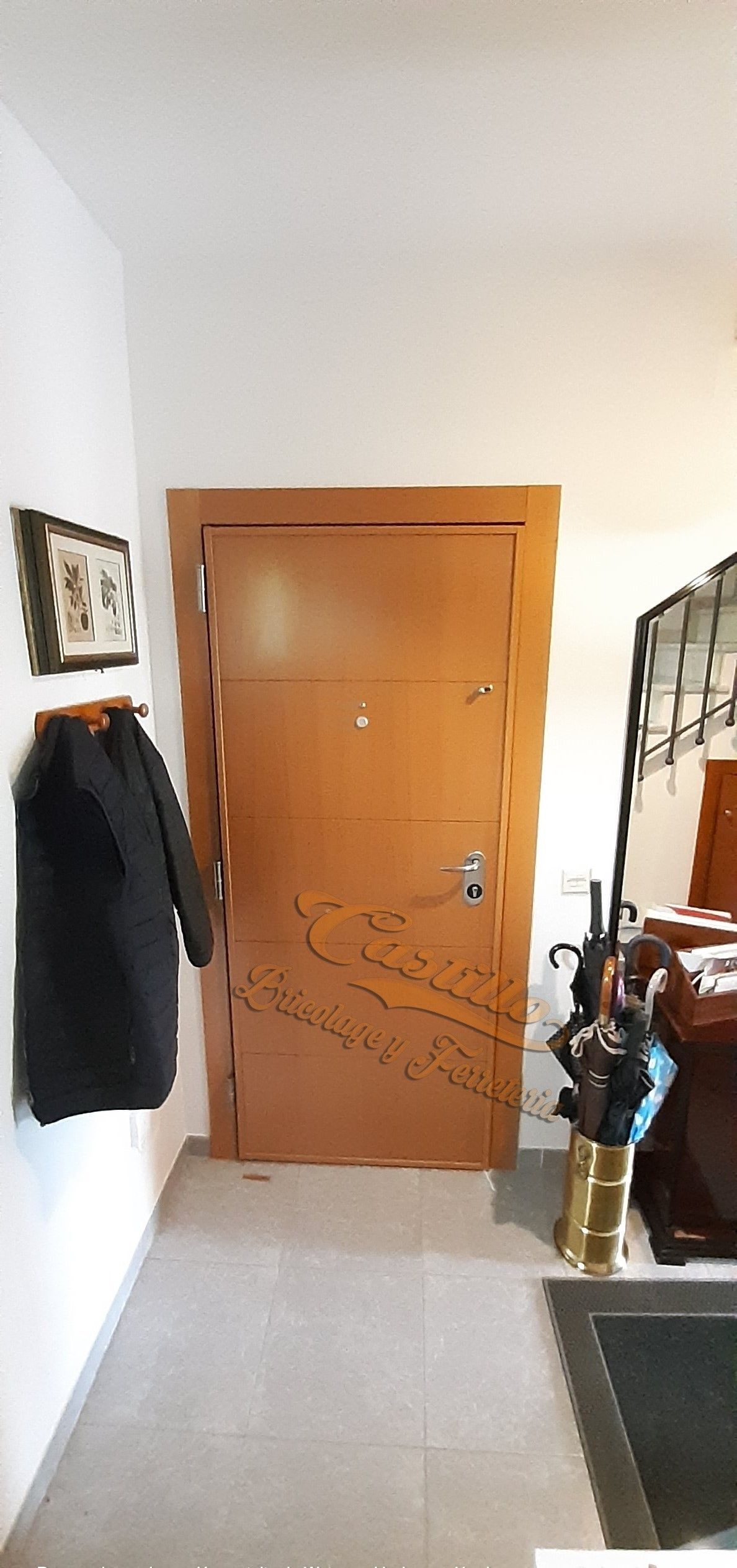 Un pasillo con una puerta y un abrigo colgado en la pared.