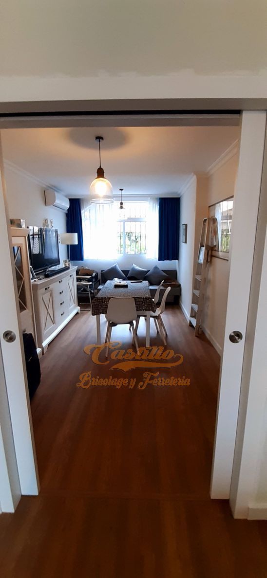 Una sala de estar con una mesa de comedor y sillas y un sofá.