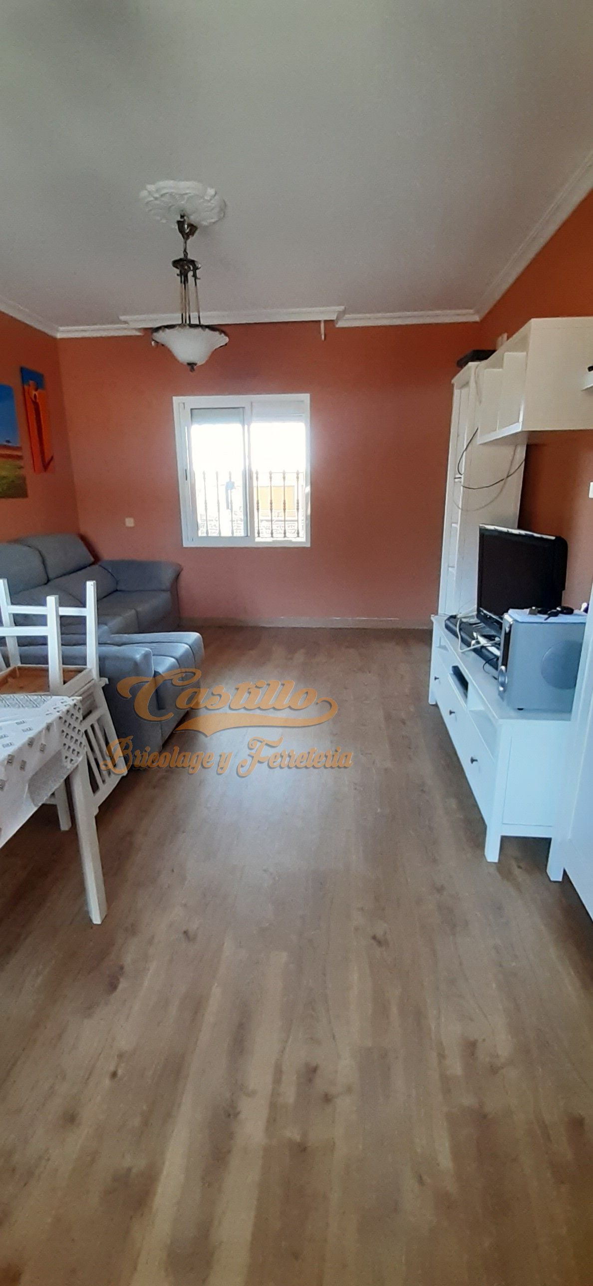 Una sala de estar con un sofá, sillas, una mesa y un televisor.