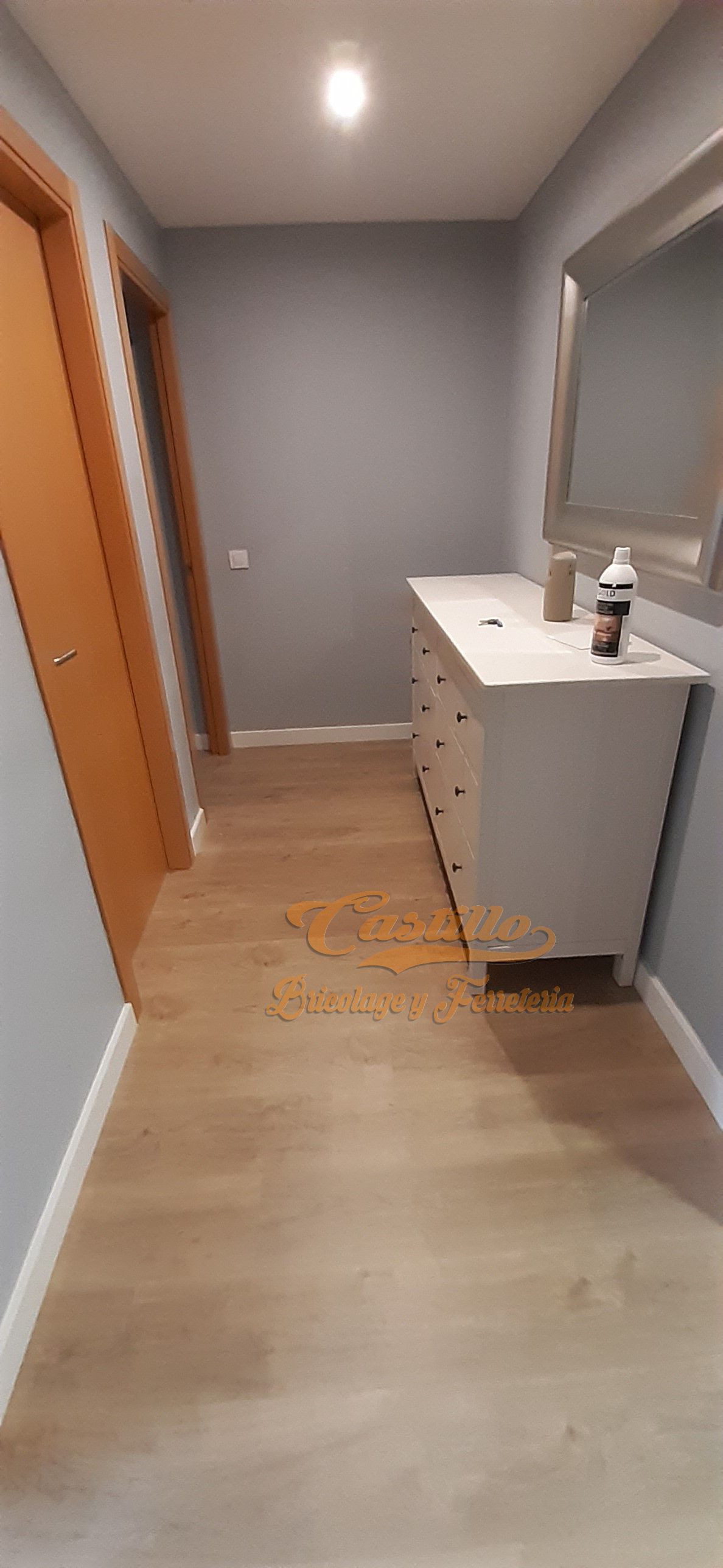 Un pasillo con una cómoda y un espejo en la pared.