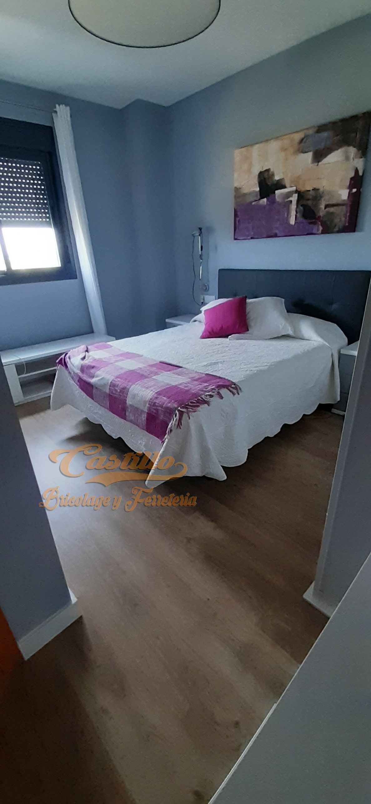 Un dormitorio con una cama grande y un cuadro en la pared.