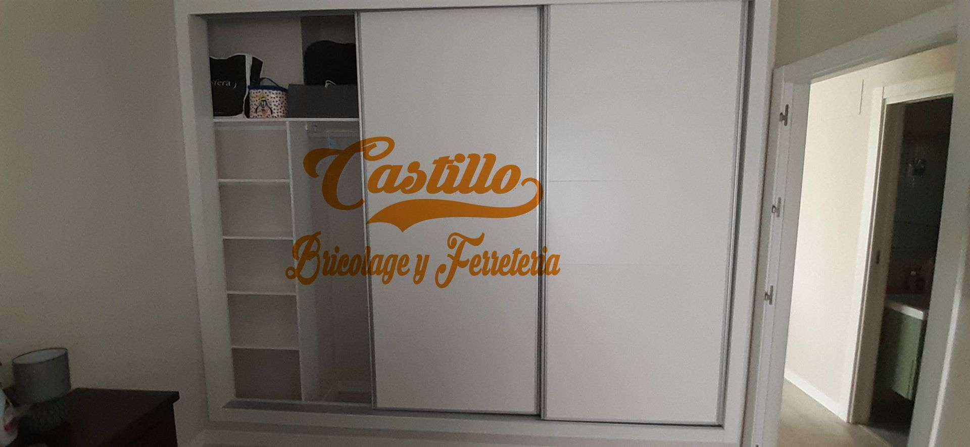 Un gran armario blanco con puertas correderas en un dormitorio.
