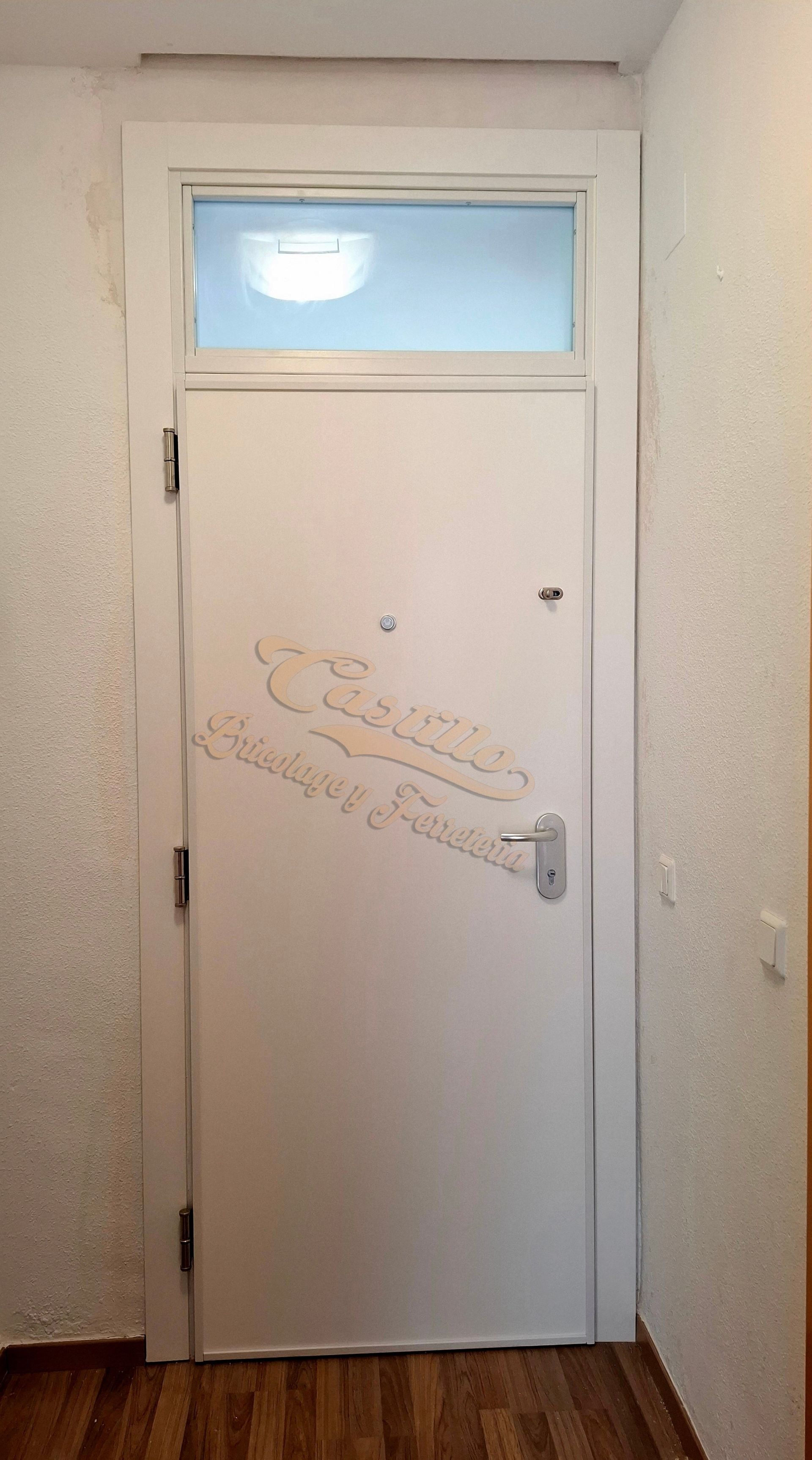 Una puerta blanca con una ventana encima en un pasillo.