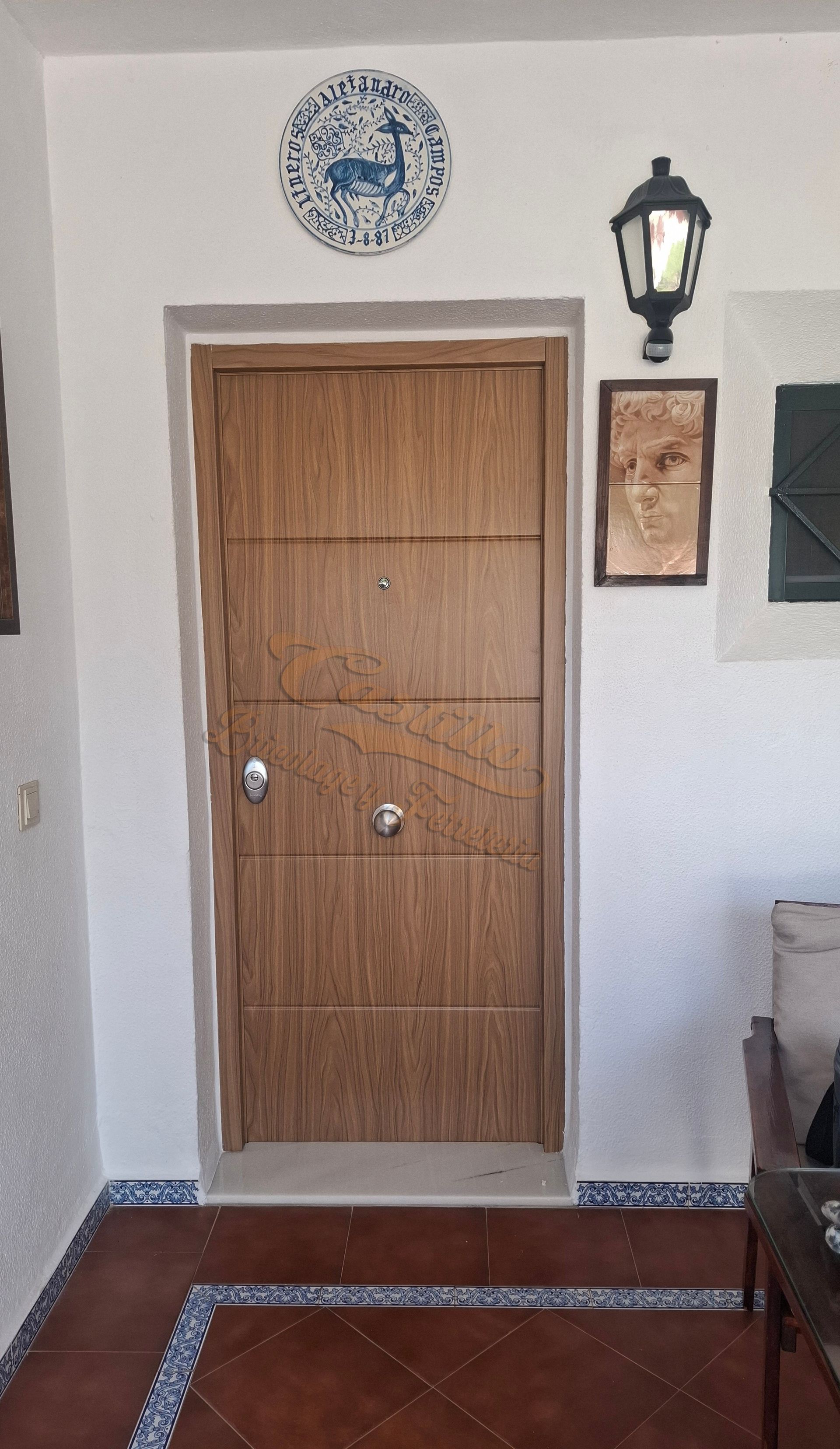 Una puerta de madera con una placa azul y blanca en la pared encima de ella.