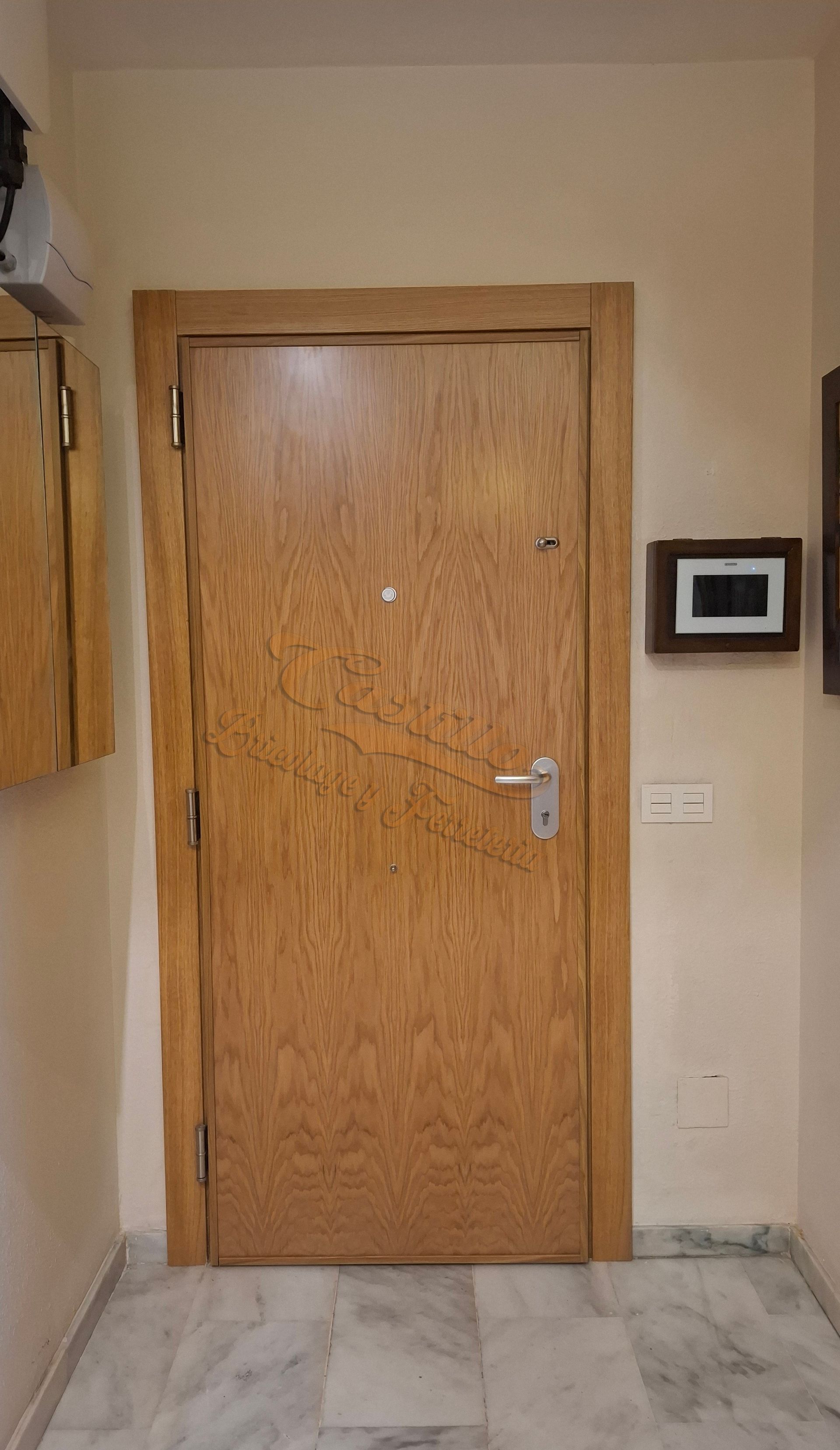 Una puerta de madera está en un pasillo al lado de una pared.