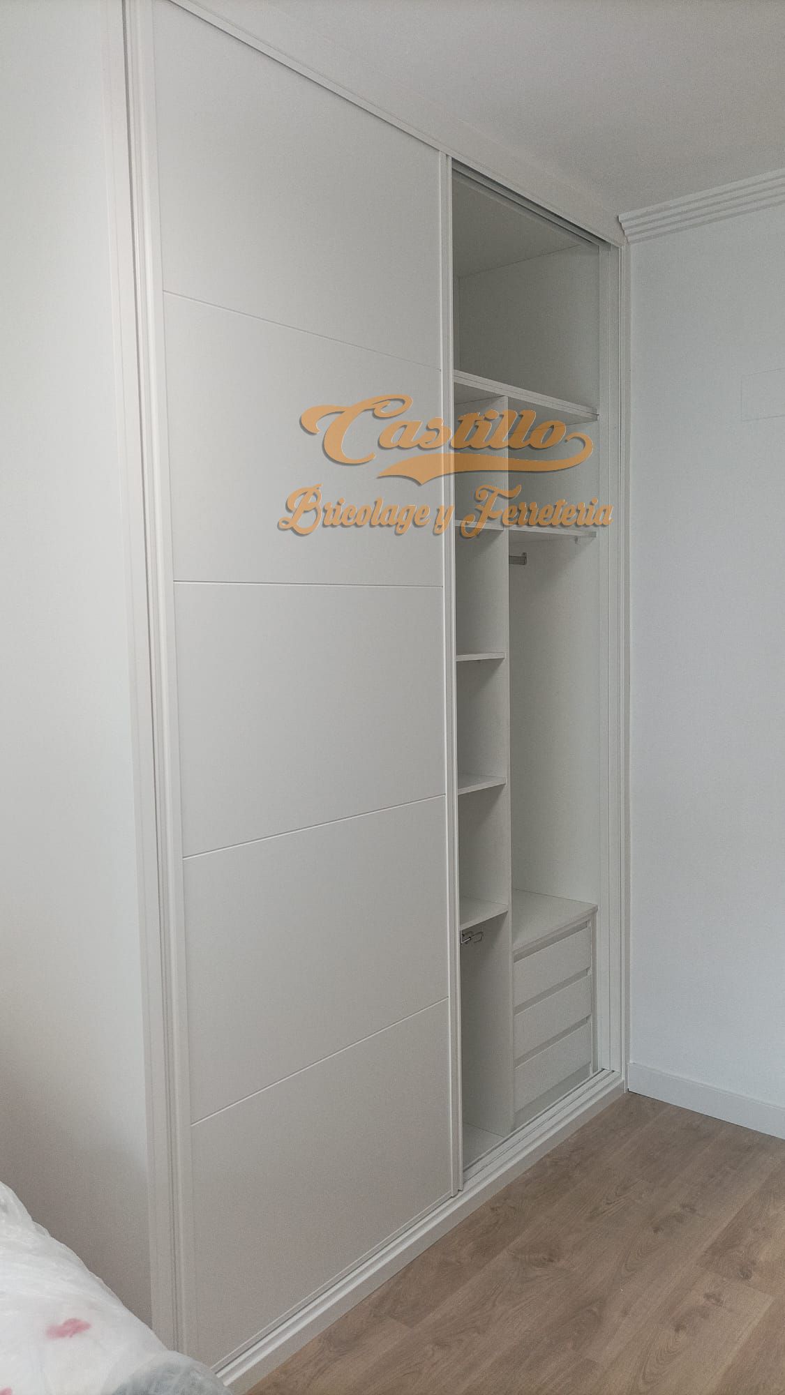 Un armario blanco con puertas correderas en un dormitorio.