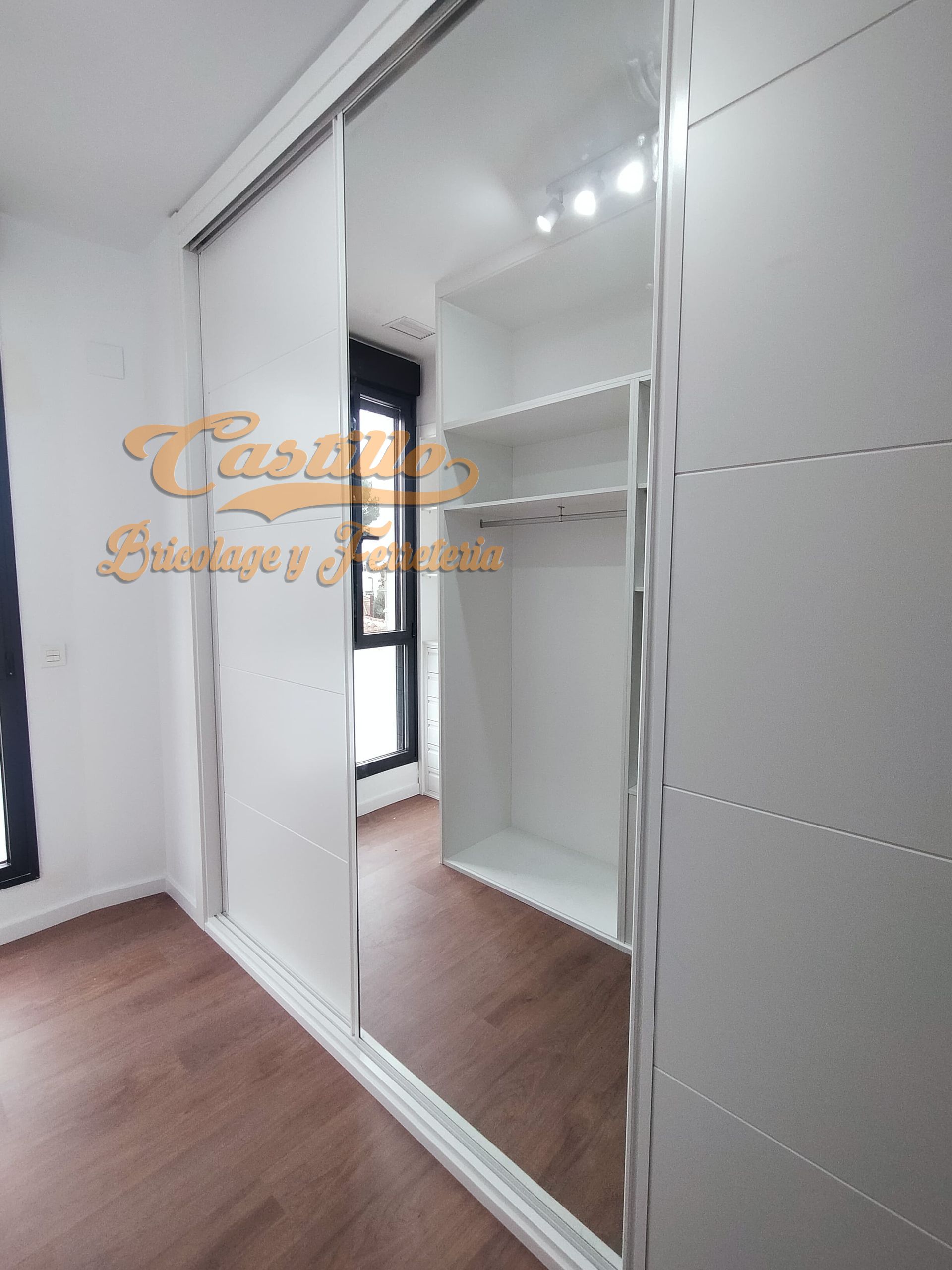 Un vestidor con puertas corredizas y un espejo grande.