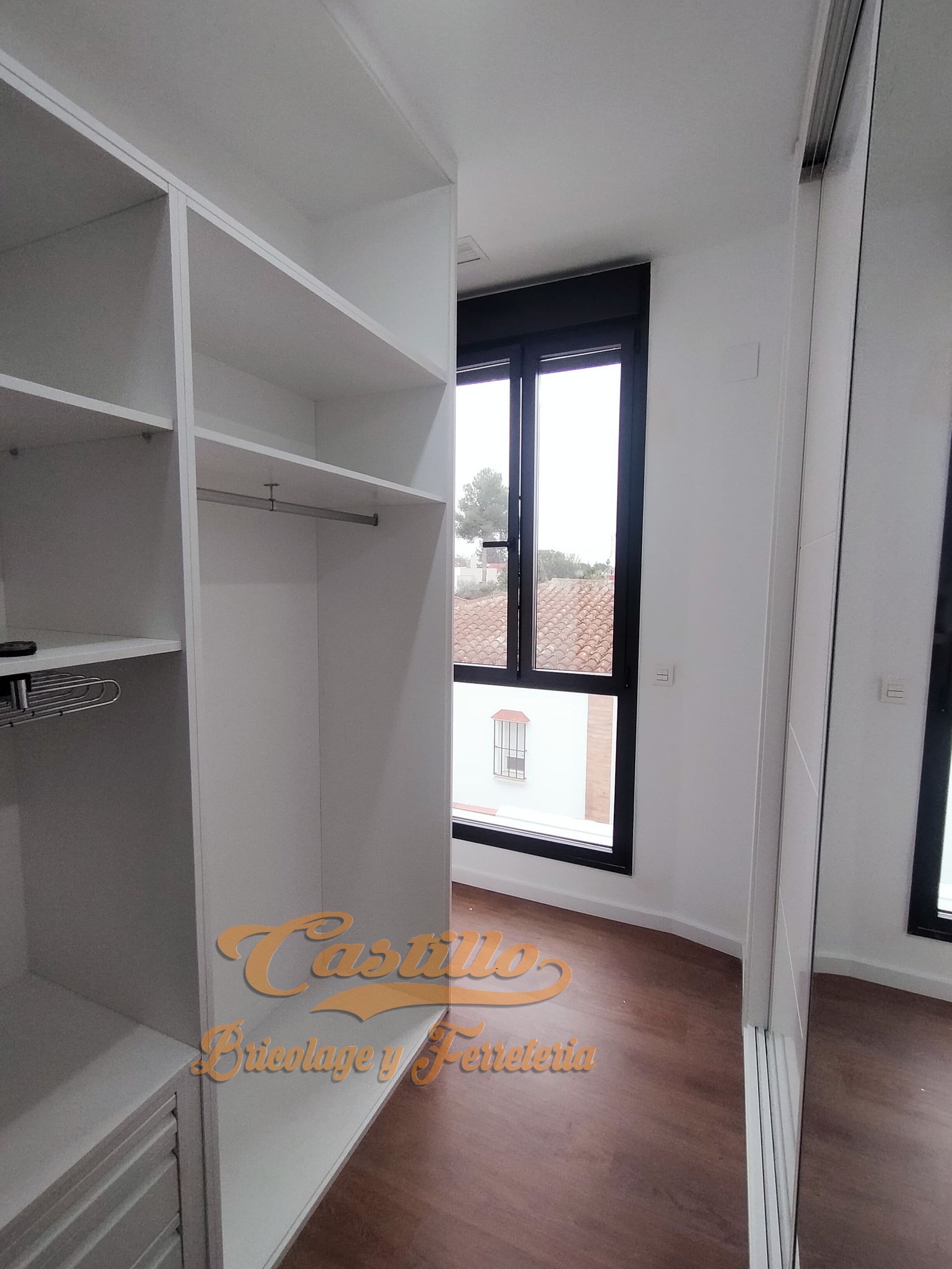 Un vestidor con muchos estantes y una ventana.