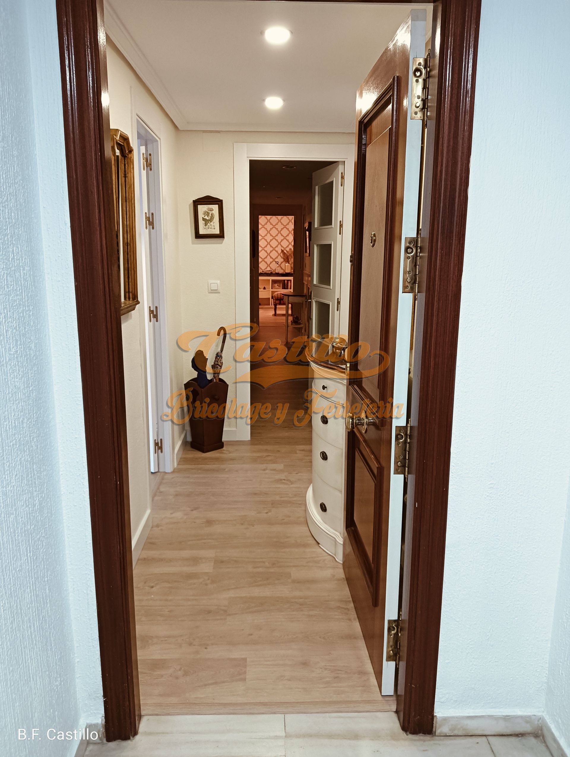 Un pasillo con suelo de madera y una puerta de madera.