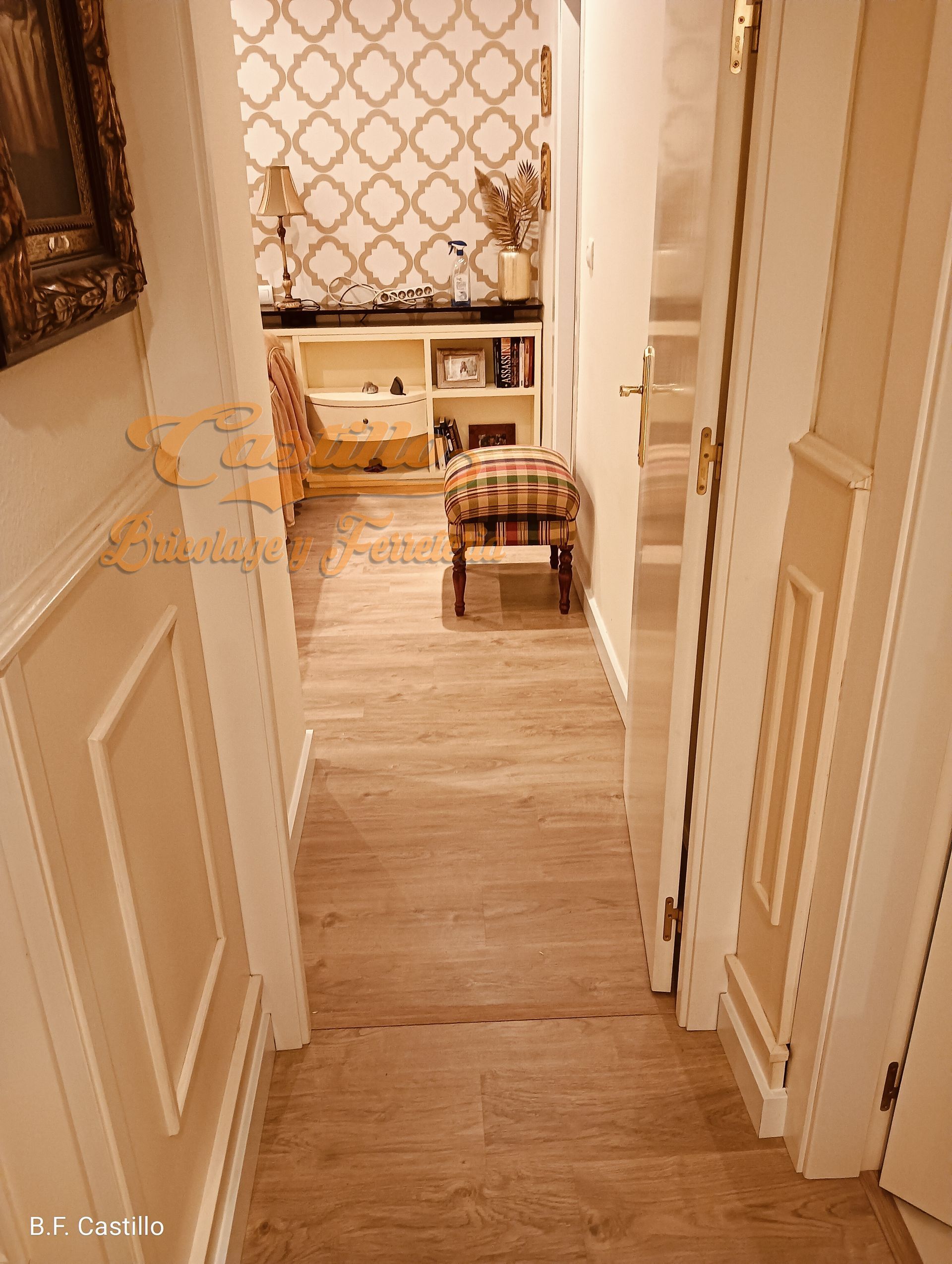 Un pasillo con suelo de madera y escaleras que conducen a una sala de estar.