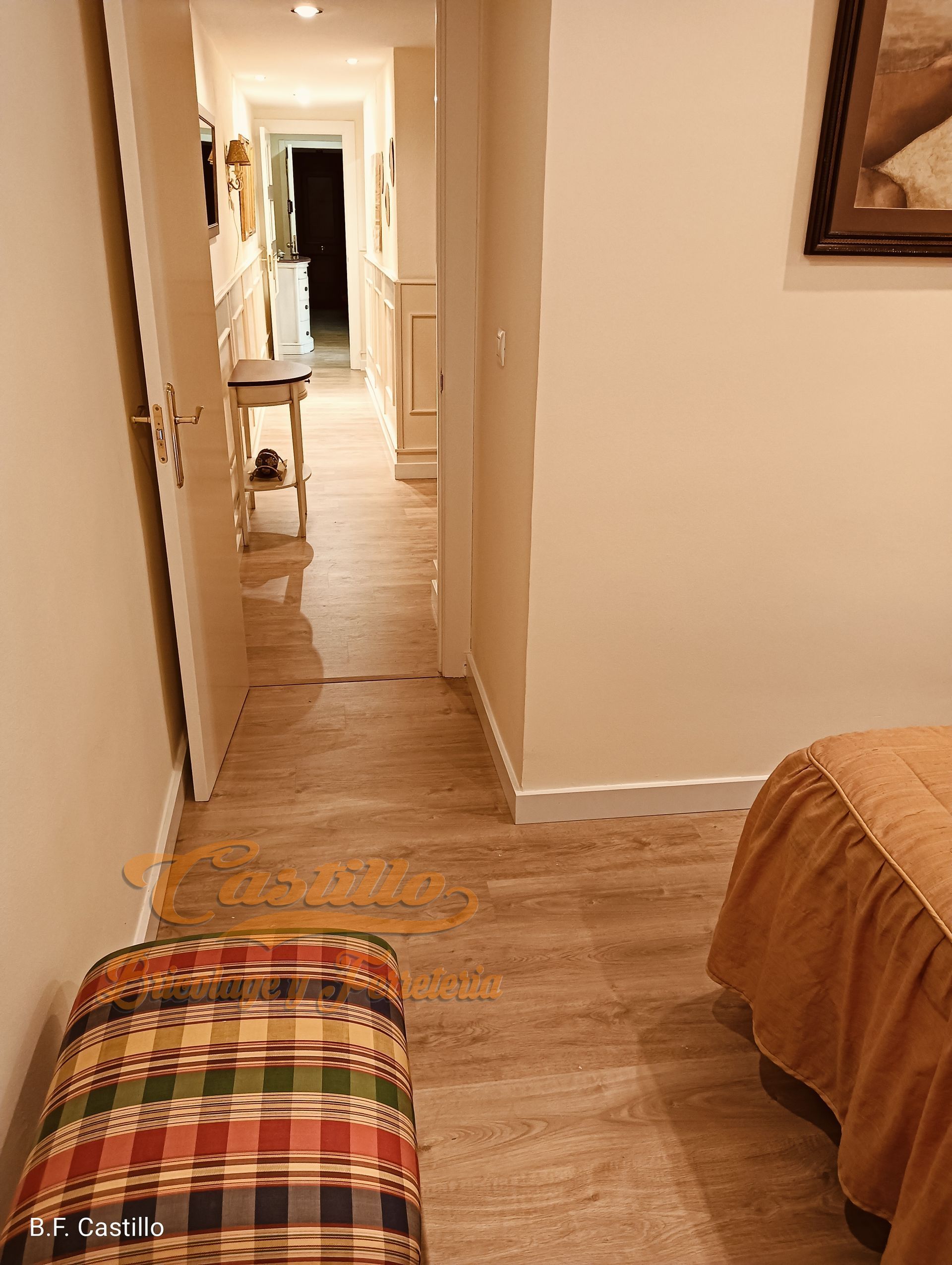 Un dormitorio con cama, otomana y pasillo.