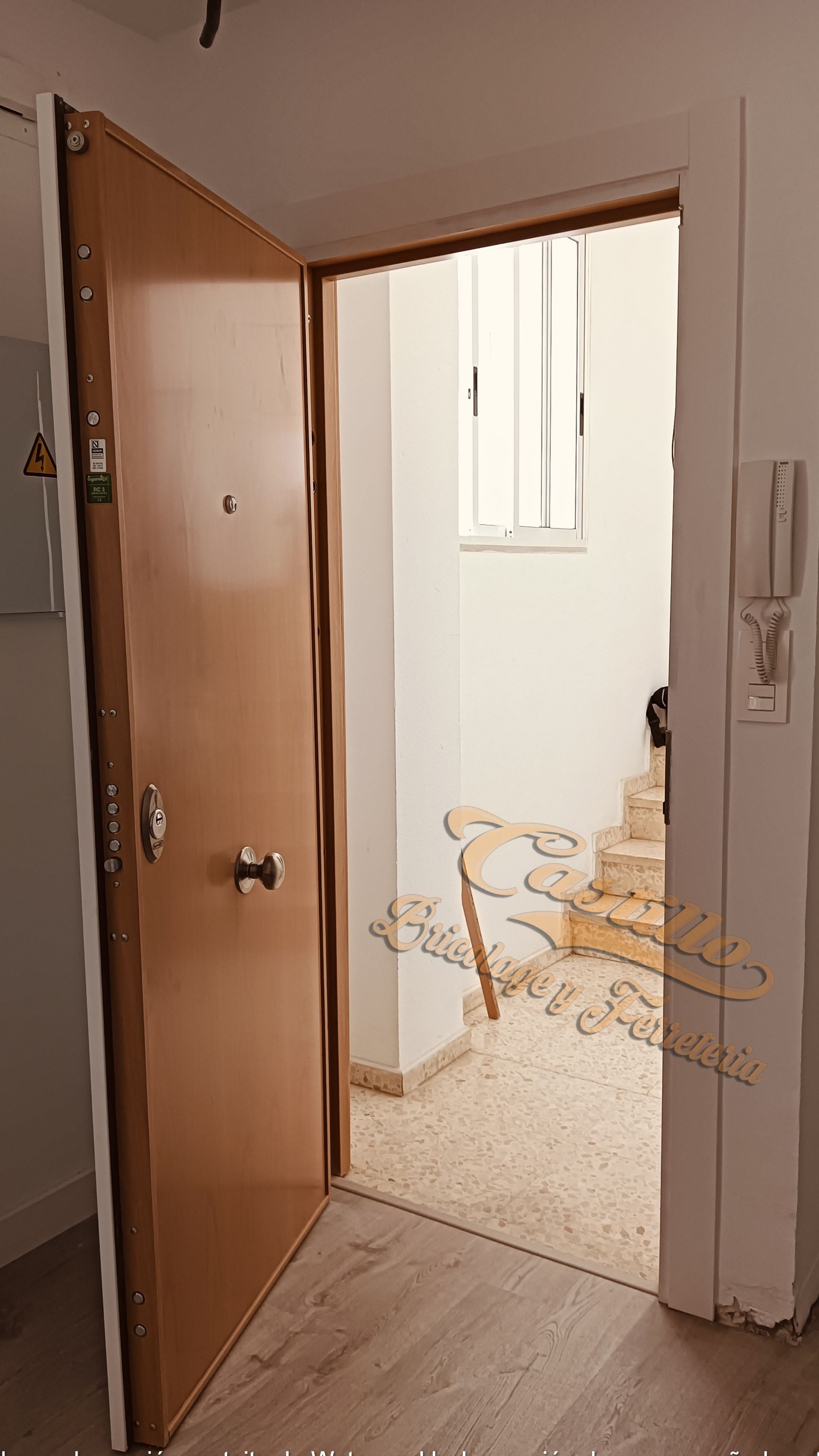 Una puerta blanca con piso de madera en un pasillo.