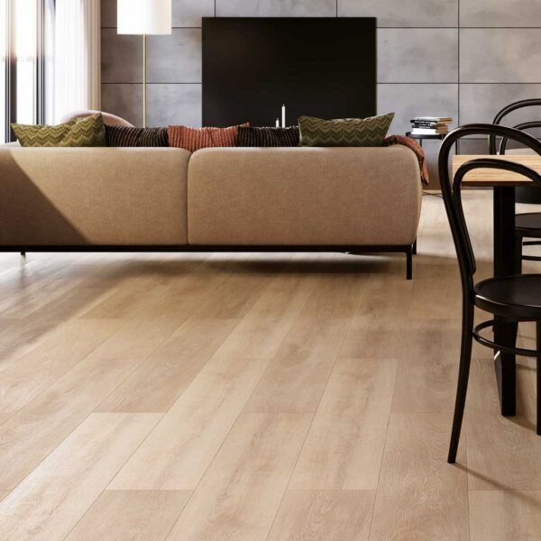 Sala de estar con piso de madera clara, sofá beige, sillas negras y un televisor en una pared gris.