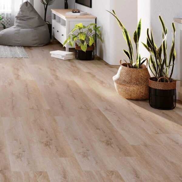 Piso con apariencia de madera clara en una habitación iluminada por el sol, con plantas en macetas y un sillón puf.