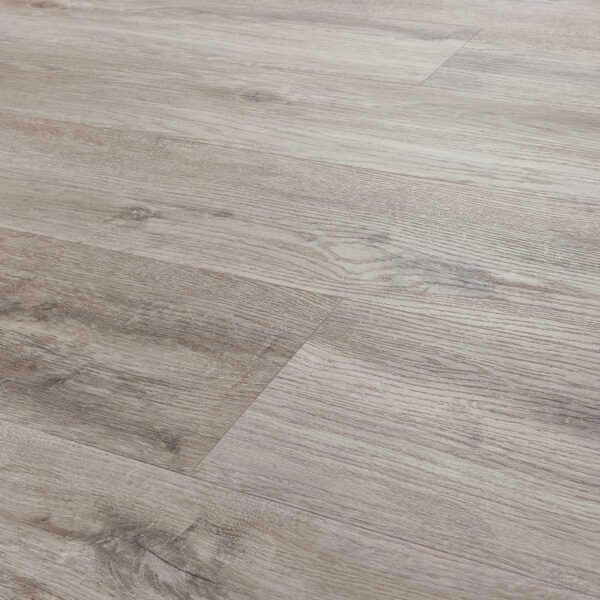 Piso laminado con apariencia de madera color gris claro y textura de veta de madera, en un ambiente interior.