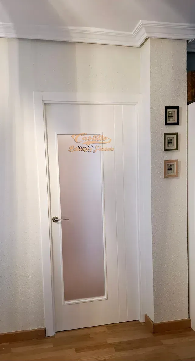 Una puerta blanca con una ventana de vidrio en una habitación.
