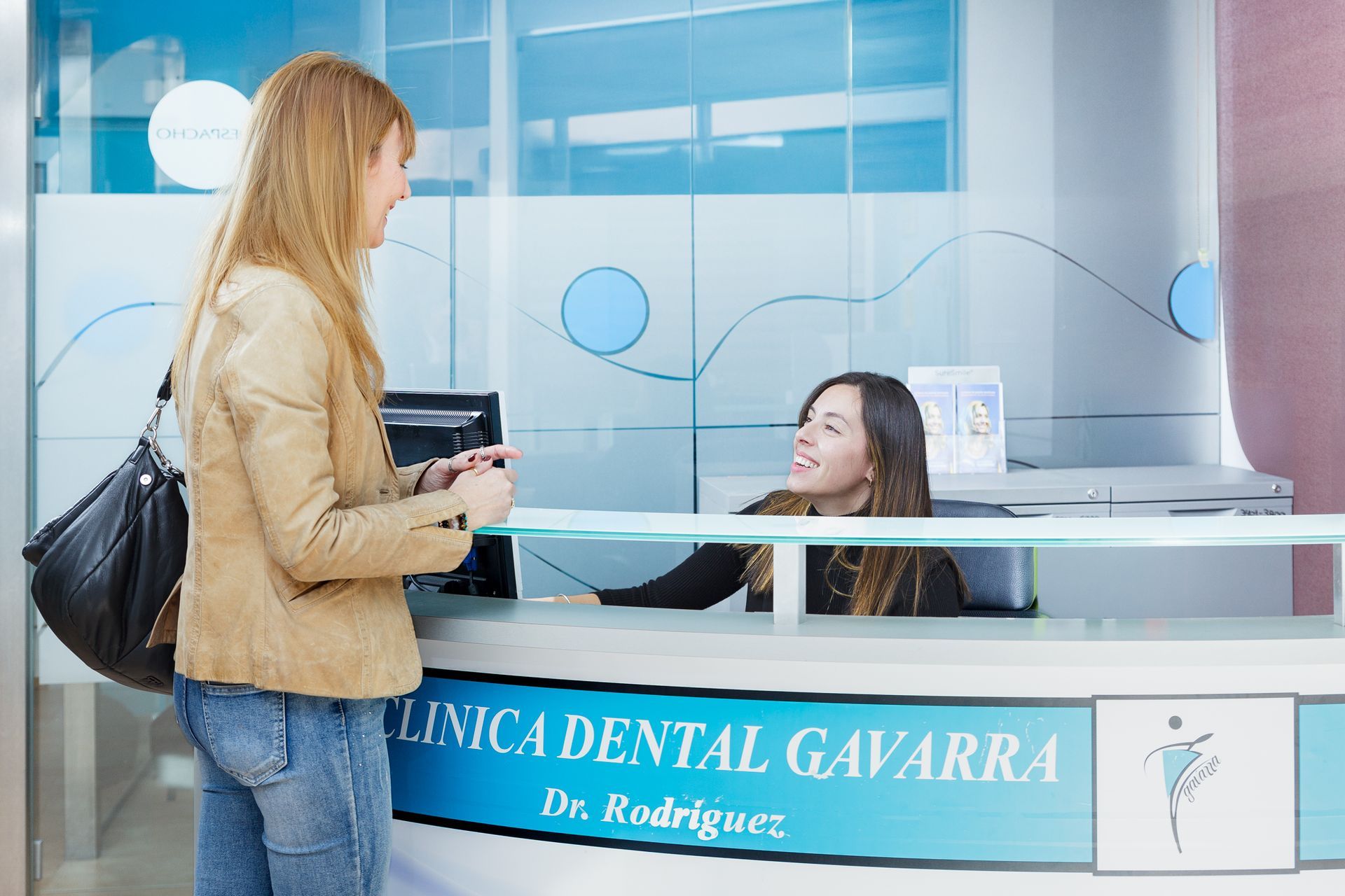 Una mujer está hablando con otra mujer en un consultorio dental.