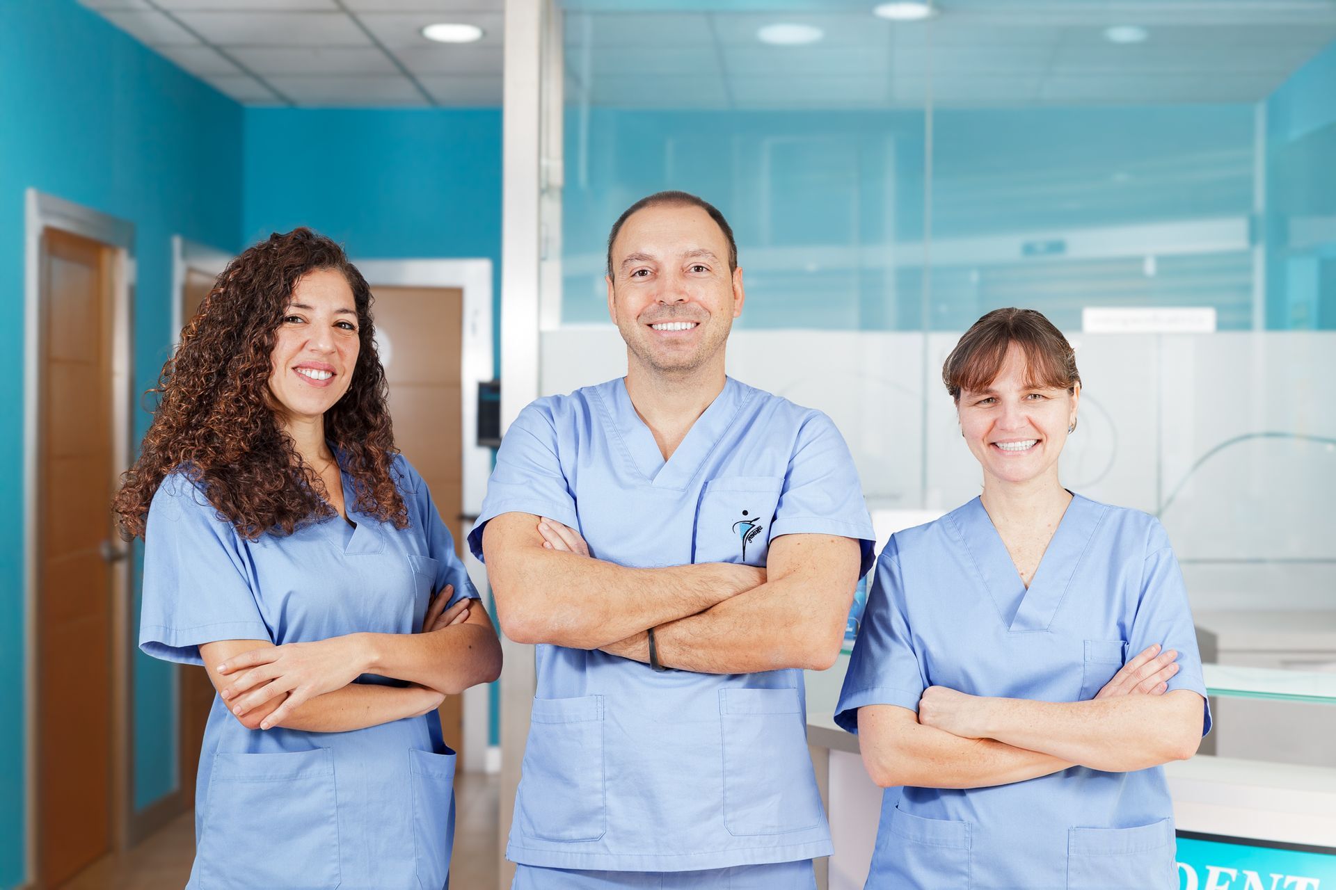 Tres personas vestidas con uniforme médico posan para una fotografía en un hospital.