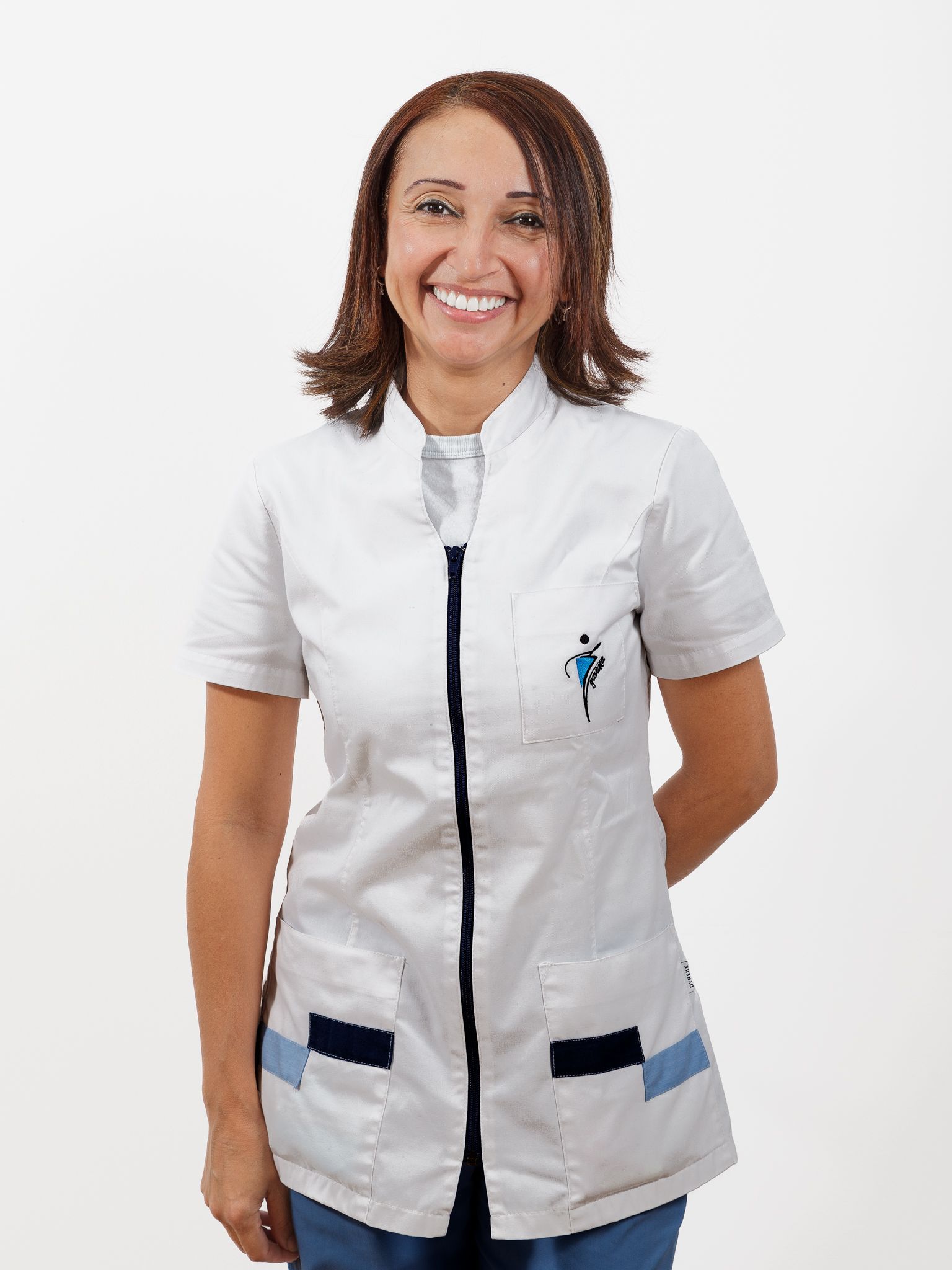 Una mujer con una bata blanca sonríe a la cámara.