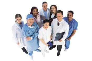 Grupo de diversos profissionais médicos sorrindo, em pé e olhando para cima.