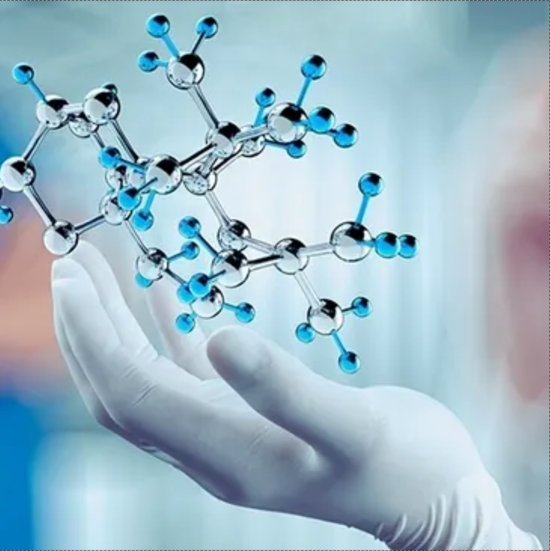 Mão enluvada segurando um modelo molecular com esferas de prata e ligações azuis em um ambiente de laboratório.