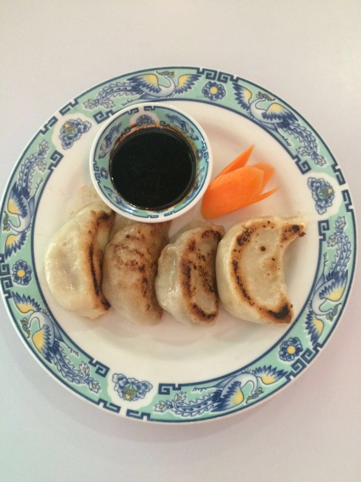 Ein Teller mit Essen mit Knödeln und Soße darauf