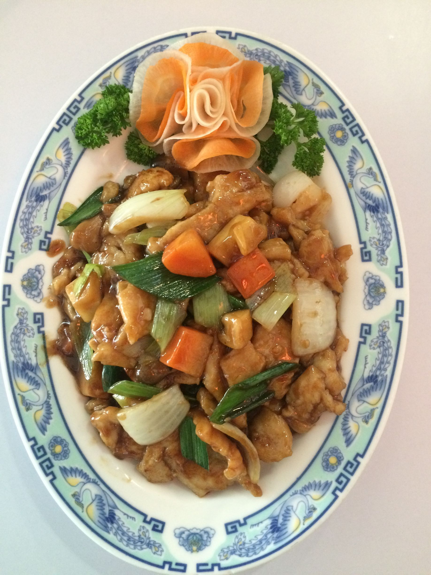 Ein Teller mit Essen, Gemüse und einer Blume darauf