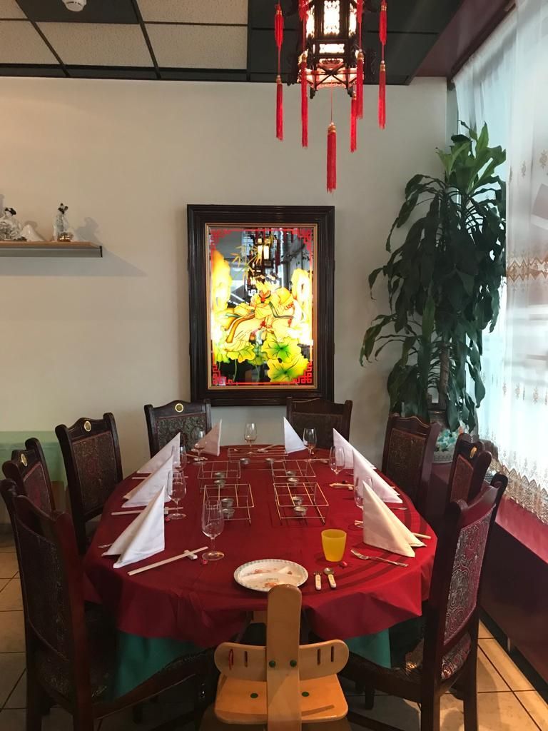 Ein Esszimmer mit Tisch und Stühlen und einem Bild an der Wand