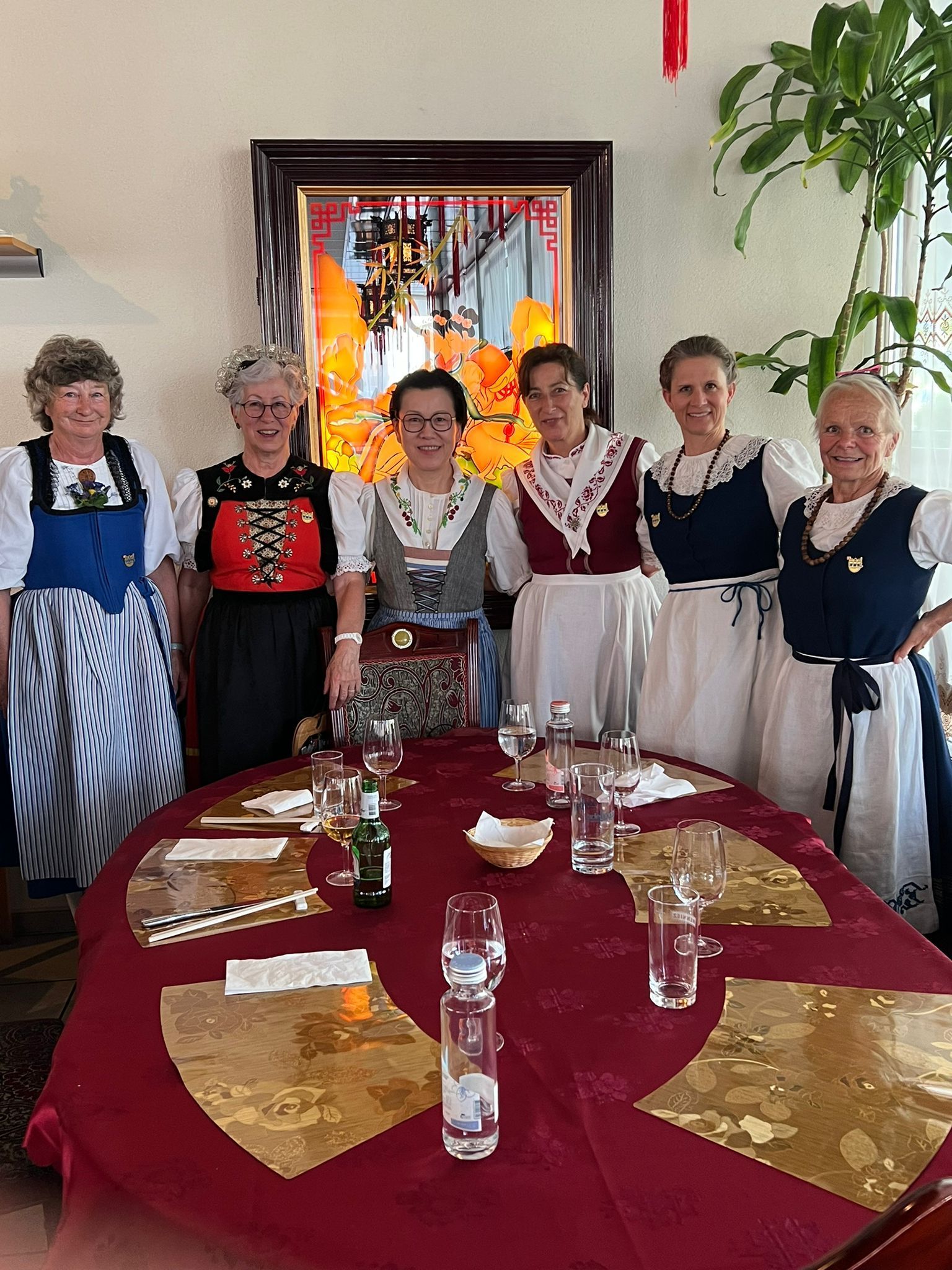 Eine Gruppe von Frauen posiert vor einem Tisch für ein Foto.