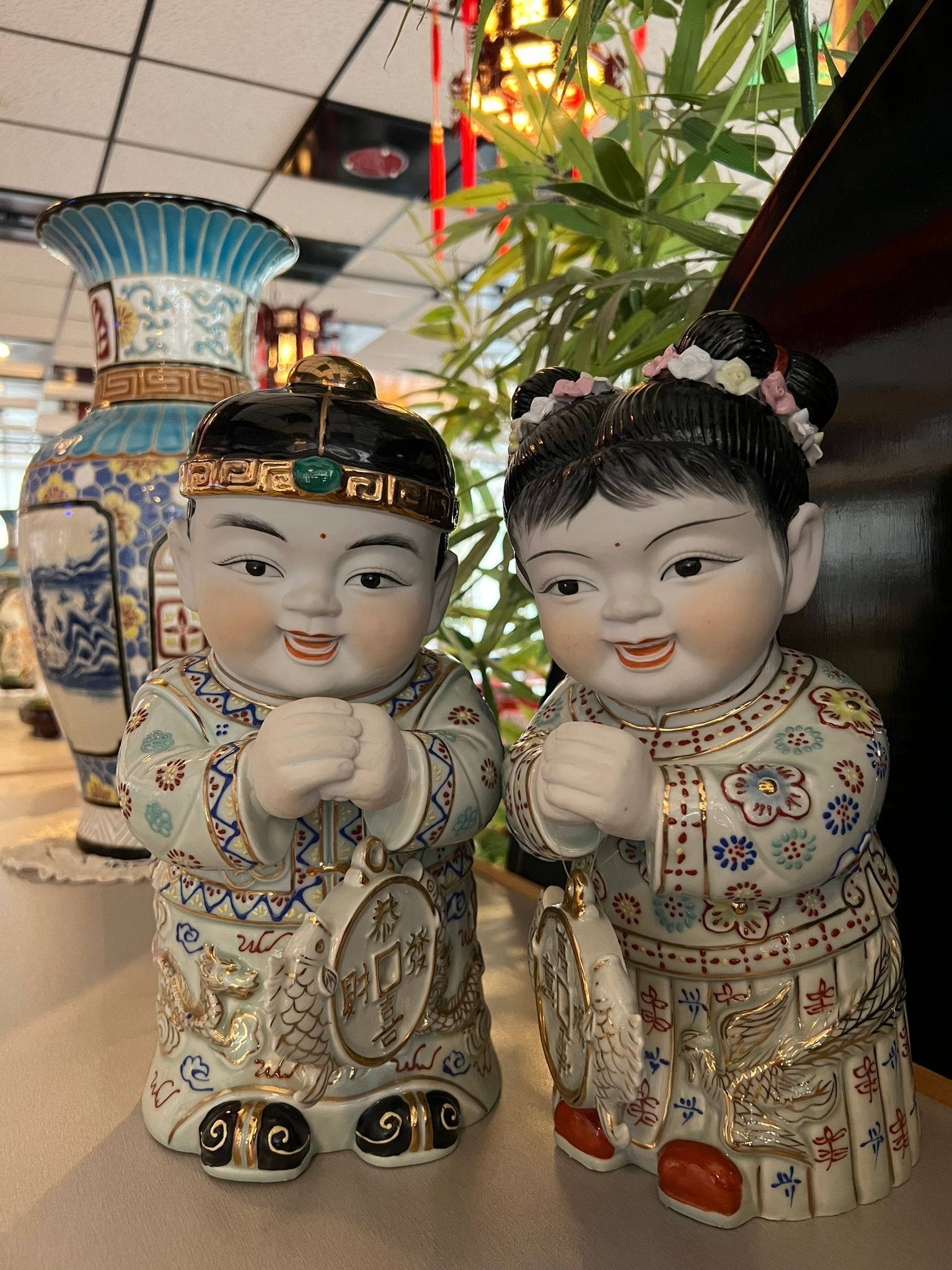 Eine Jungen- und eine Mädchenfigur sitzen nebeneinander auf einem Tisch.