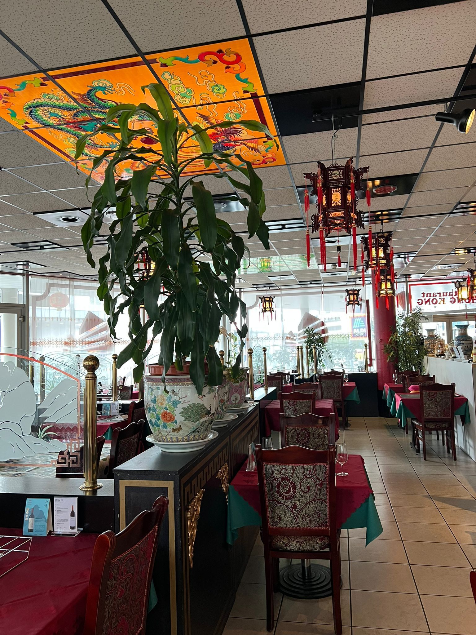 Ein Restaurant mit Tischen und Stühlen und einer Pflanze in der Mitte